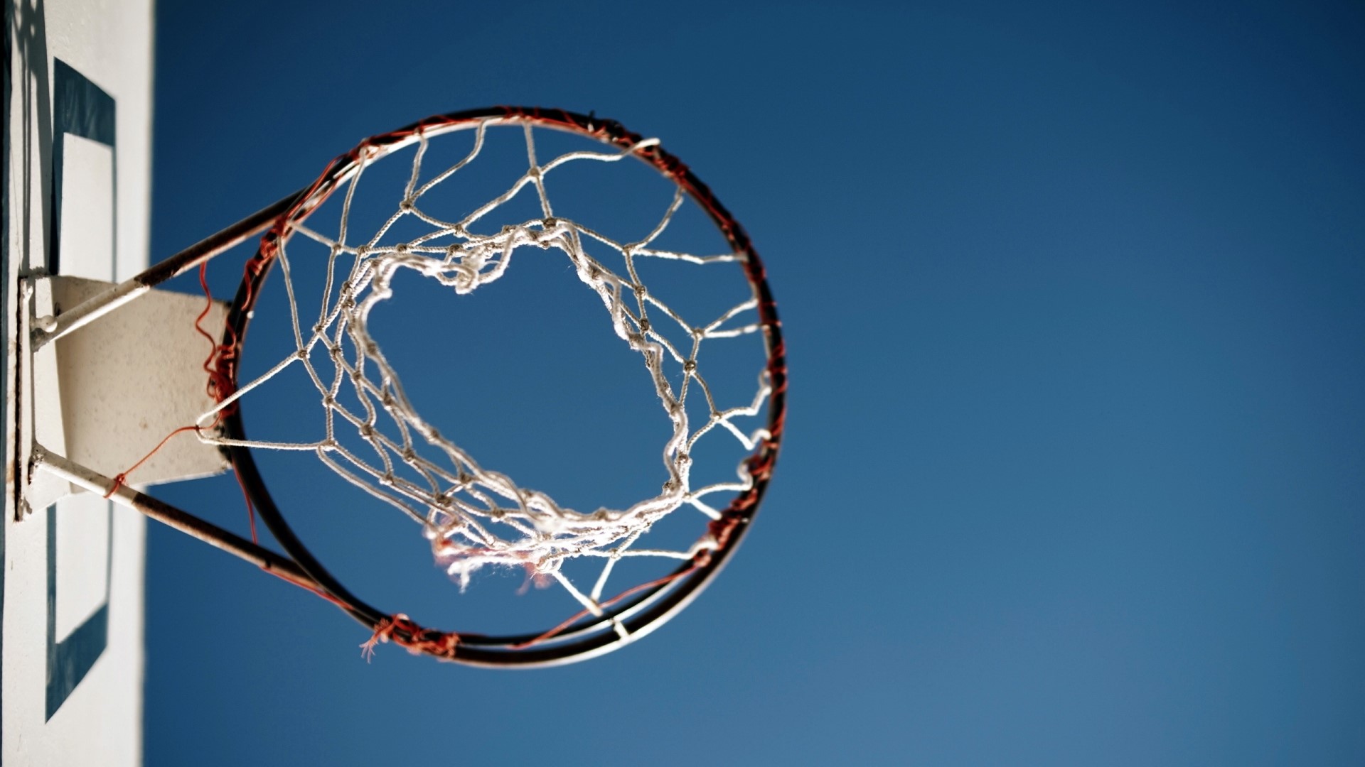 Basketball hoop and net against blue sky HD Wallpaper