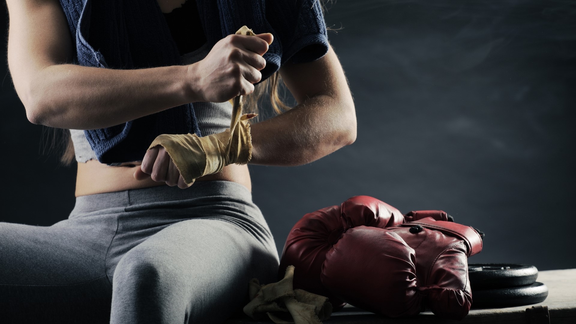 Boxer wrapping hands with red gloves nearby HD Wallpaper