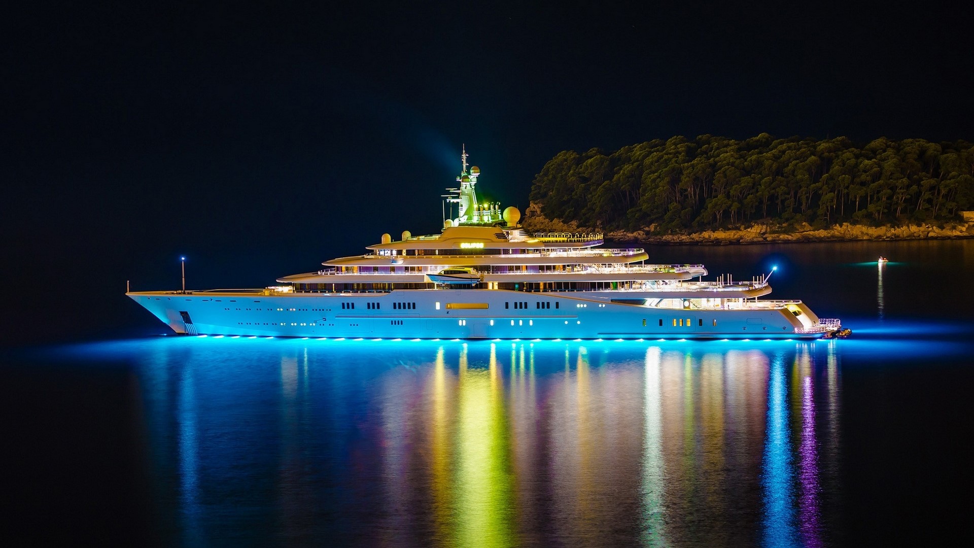 Luxury yacht illuminated at night with colorful lights HD Wallpaper