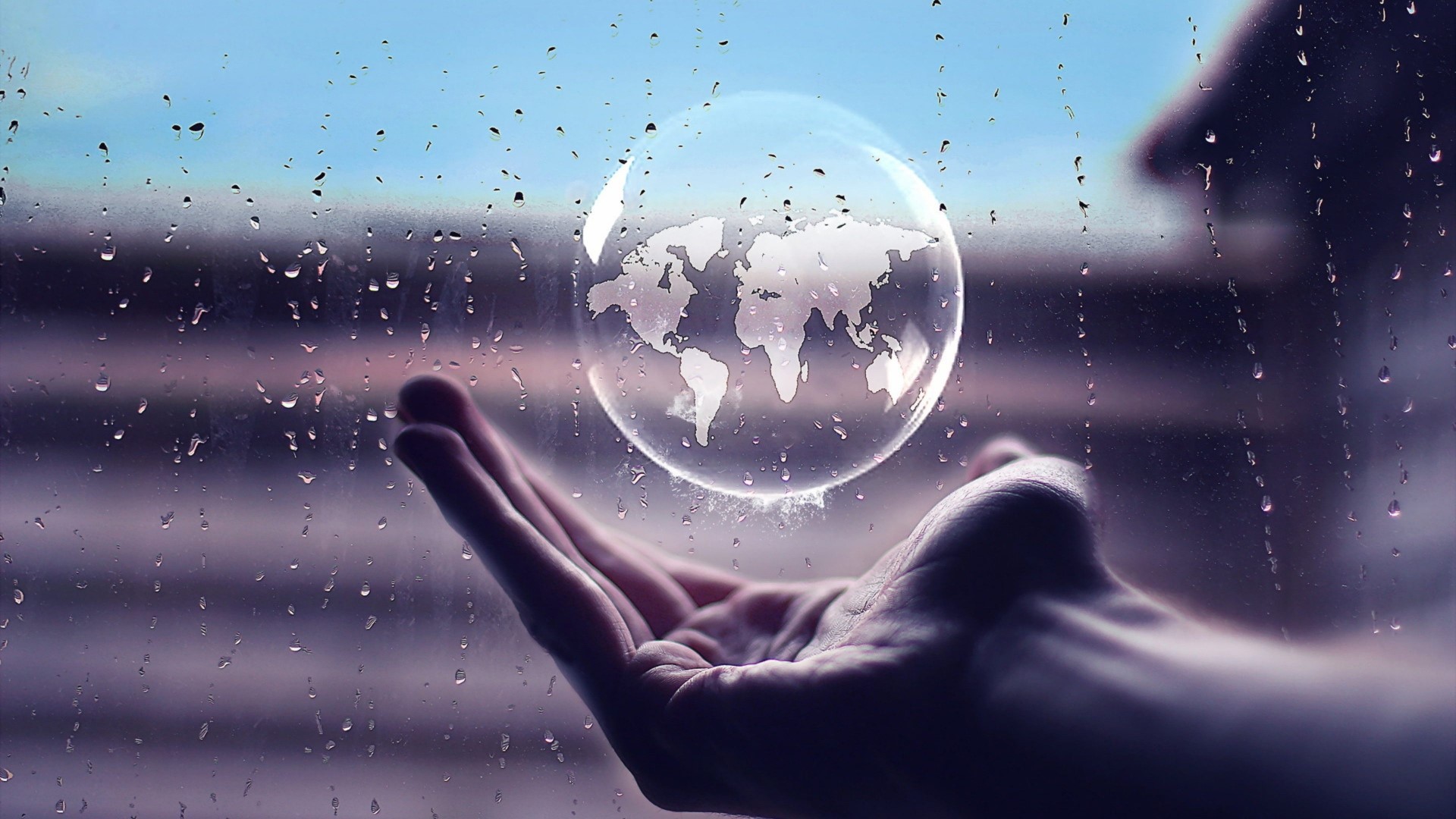 World map in a bubble over a hand HD Wallpaper