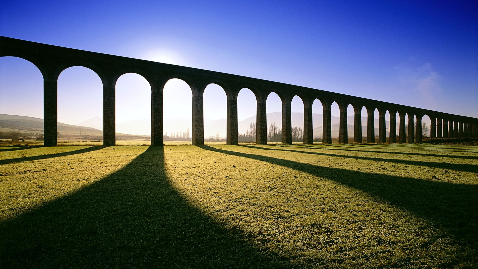 Stone Aqueduct with Arches and Shadows HD Wallpaper