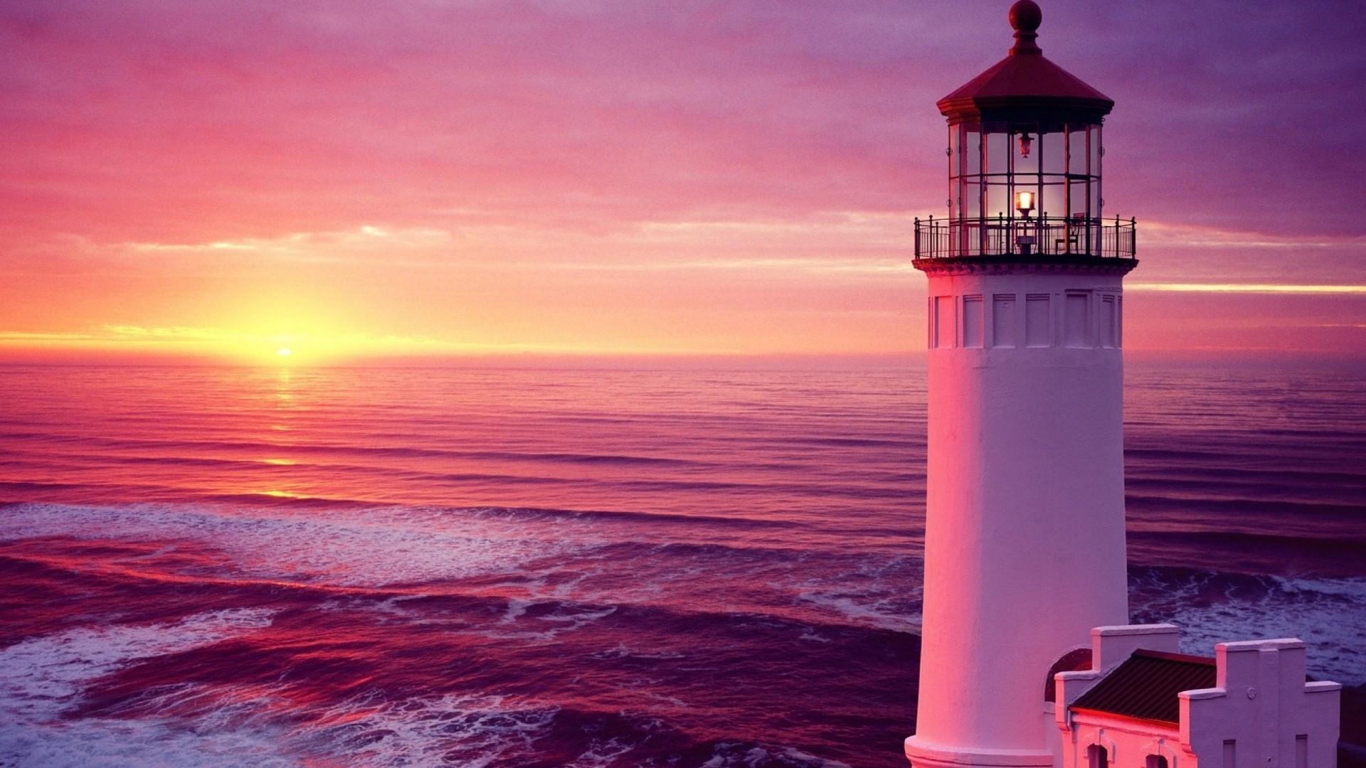 Lighthouse at sunset over the ocean HD Wallpaper