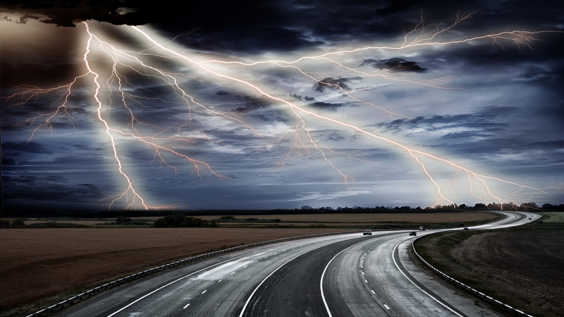 Lightning strikes over a highway during a storm HD Wallpaper