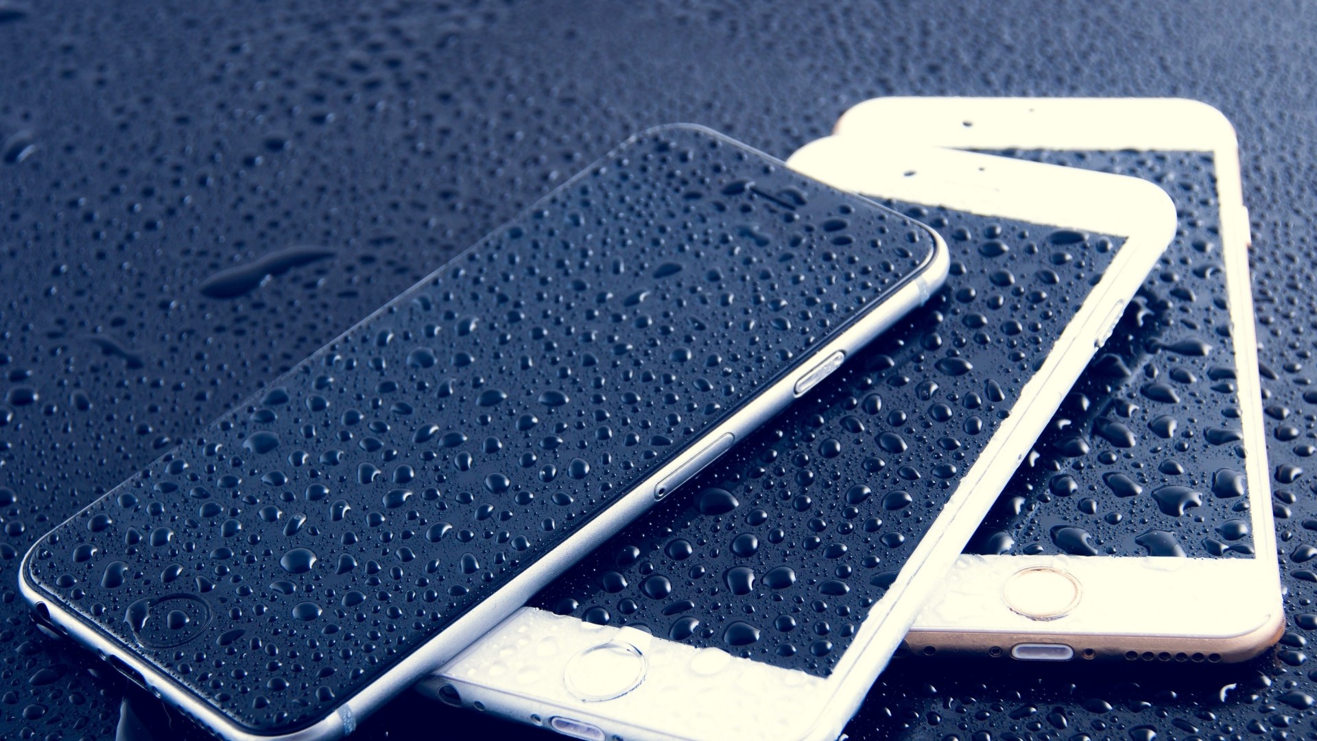 Three iPhones covered in water droplets HD Wallpaper