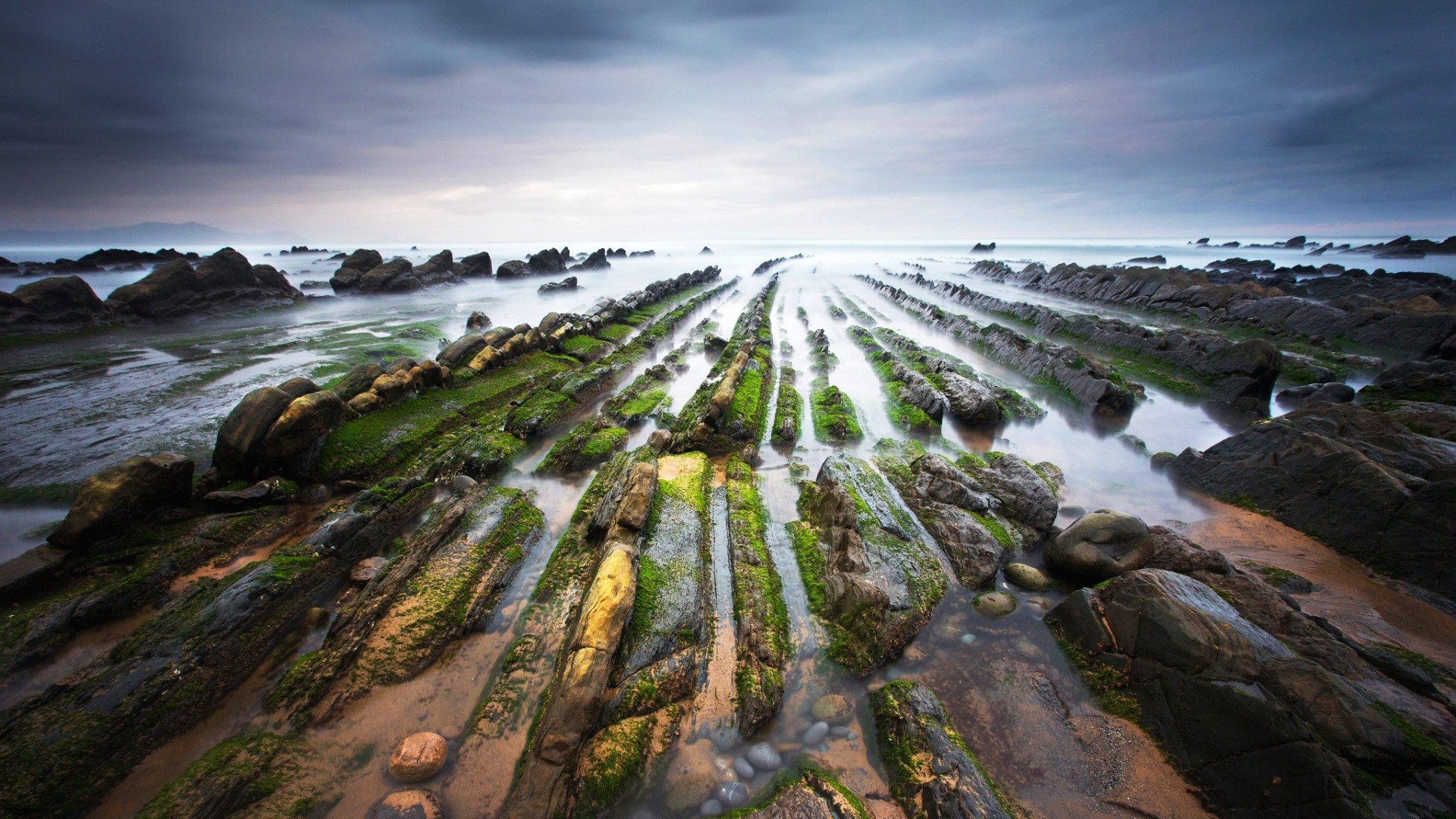 Rocky coastline with green moss and ocean HD Wallpaper