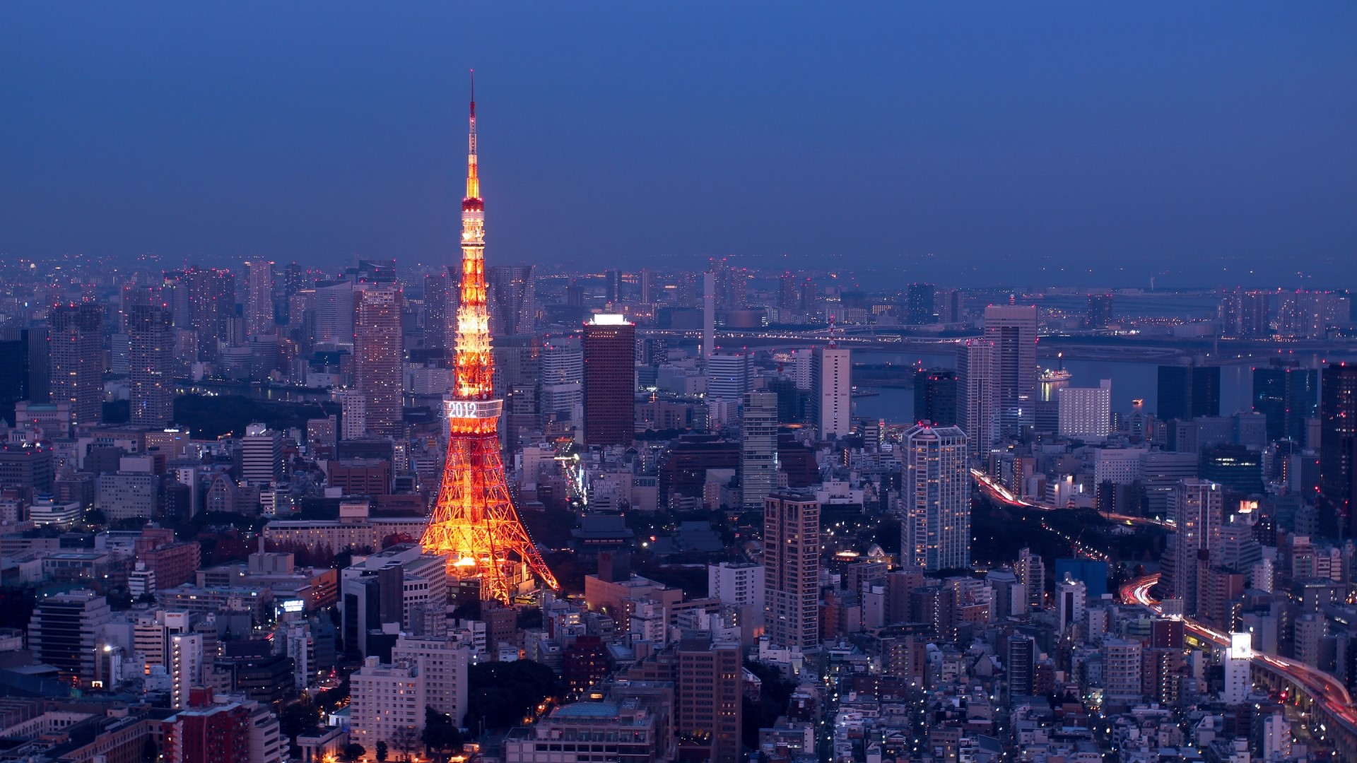 Tokyo Tower illuminated at dusk with city skyline HD Wallpaper