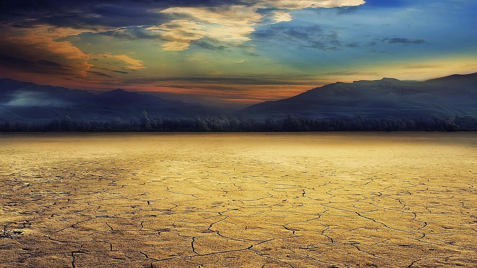 Cracked desert landscape with mountains and colorful sky HD Wallpaper
