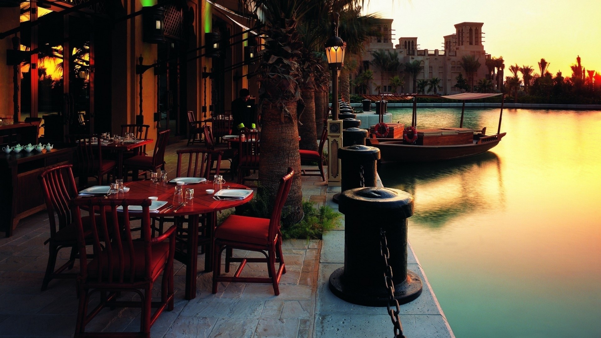 Outdoor cafe by the water at sunset HD Wallpaper