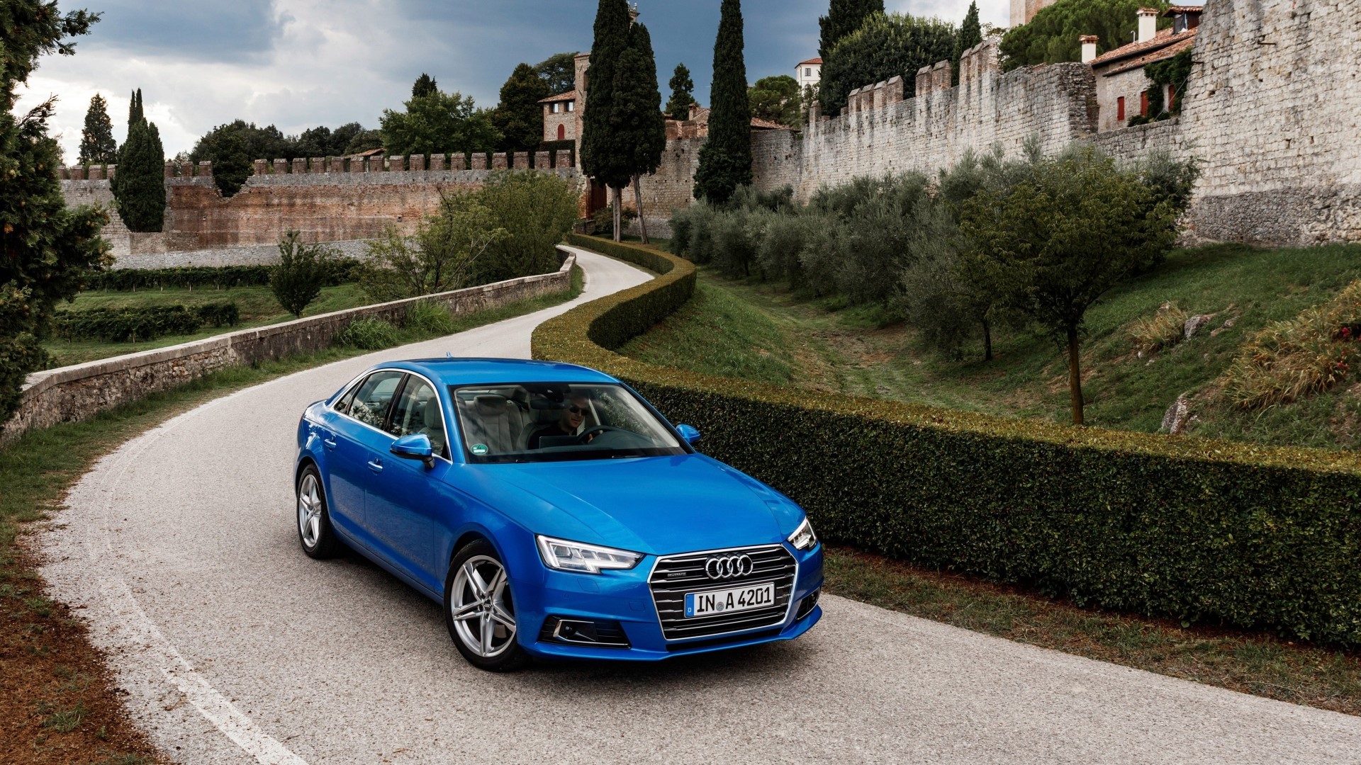Blue Audi A4 driving on a scenic road HD Wallpaper