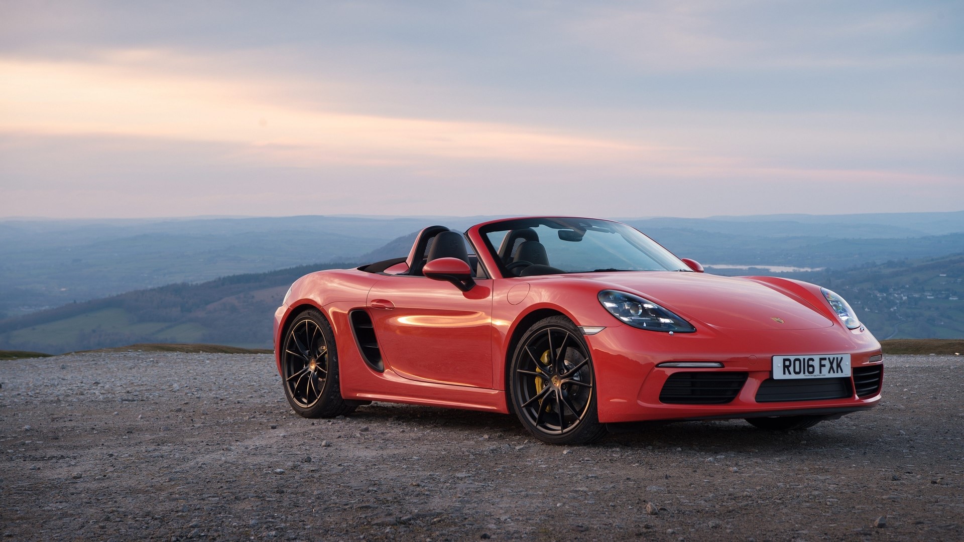 Red Porsche Boxster convertible car on gravel road HD Wallpaper