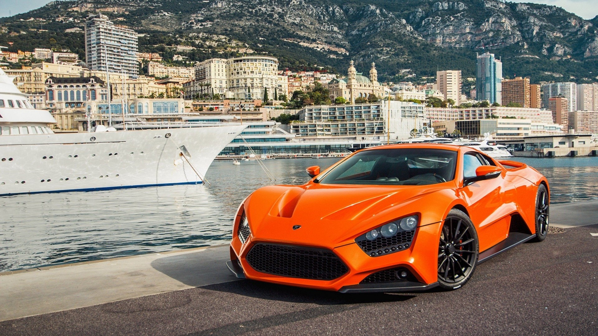 Orange Zenvo ST1 supercar parked by a yacht in Monaco HD Wallpaper