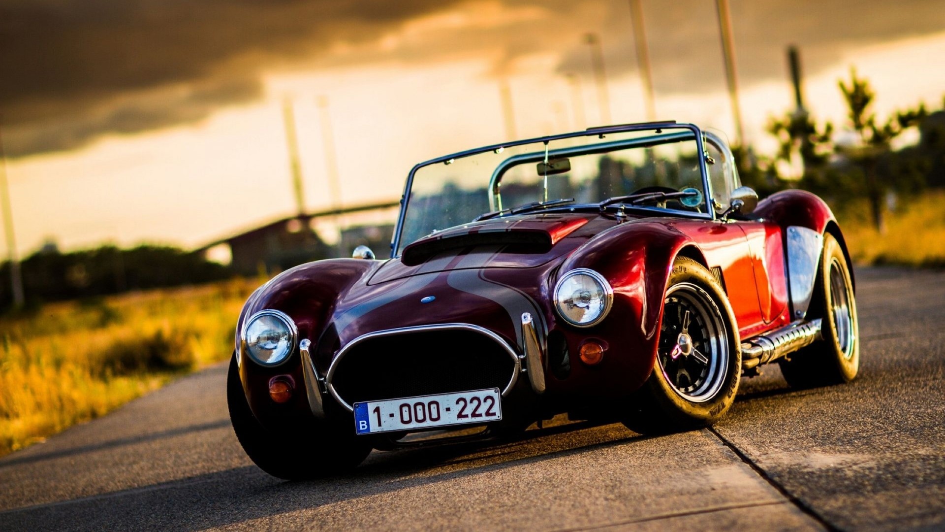 Classic red convertible sports car on a road HD Wallpaper