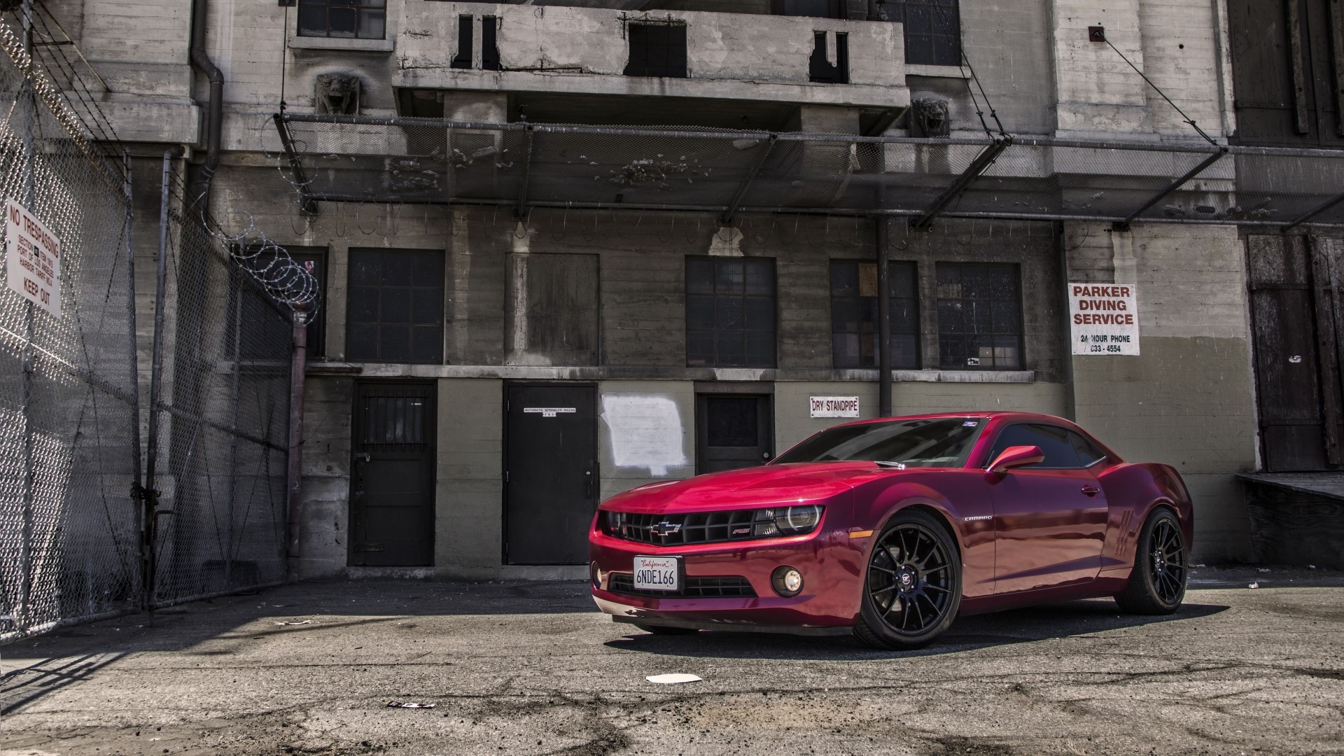 Red Chevrolet Camaro RS parked near industrial building HD Wallpaper