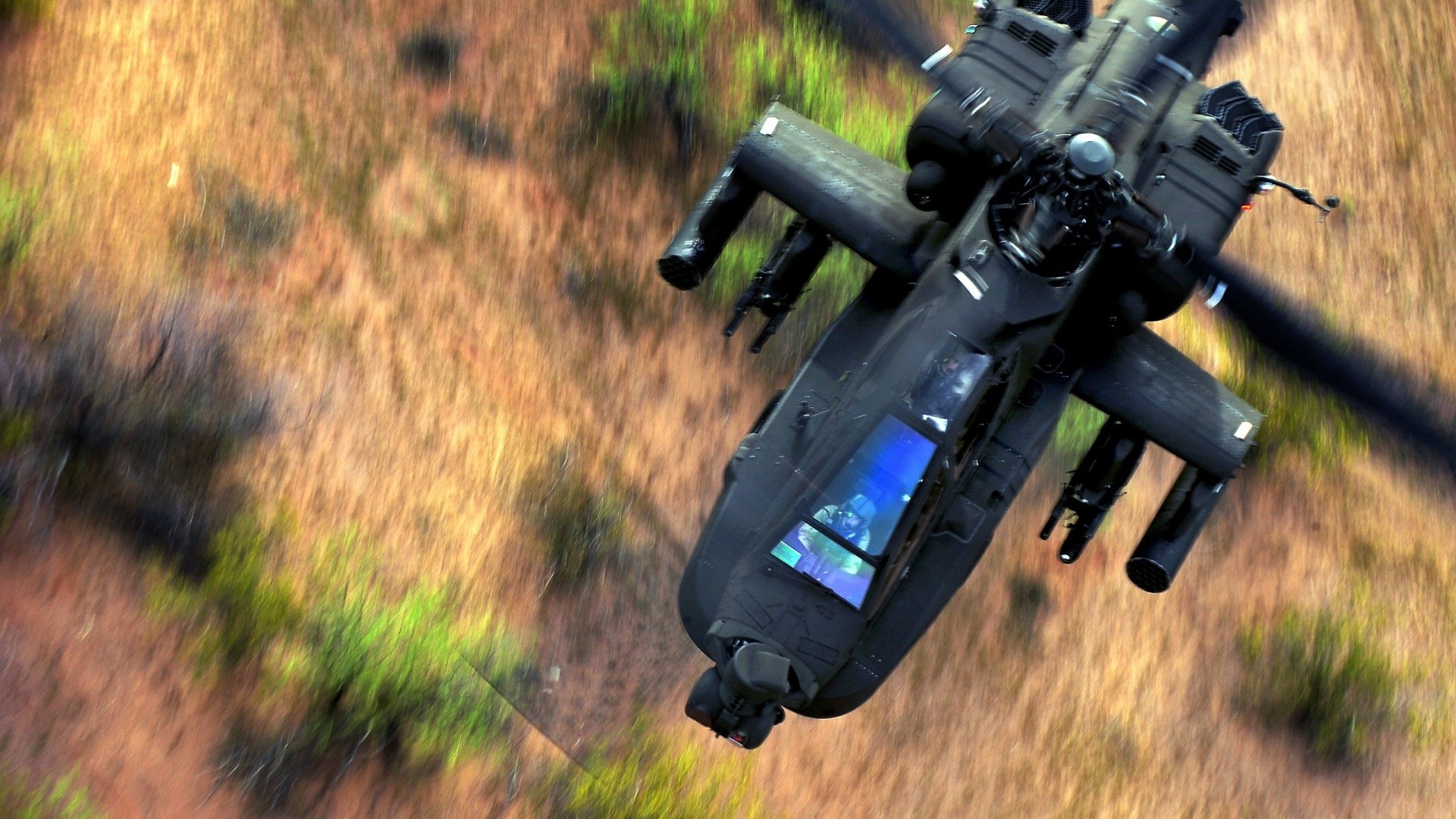 AH-64 Apache Helicopter flying over terrain HD Wallpaper
