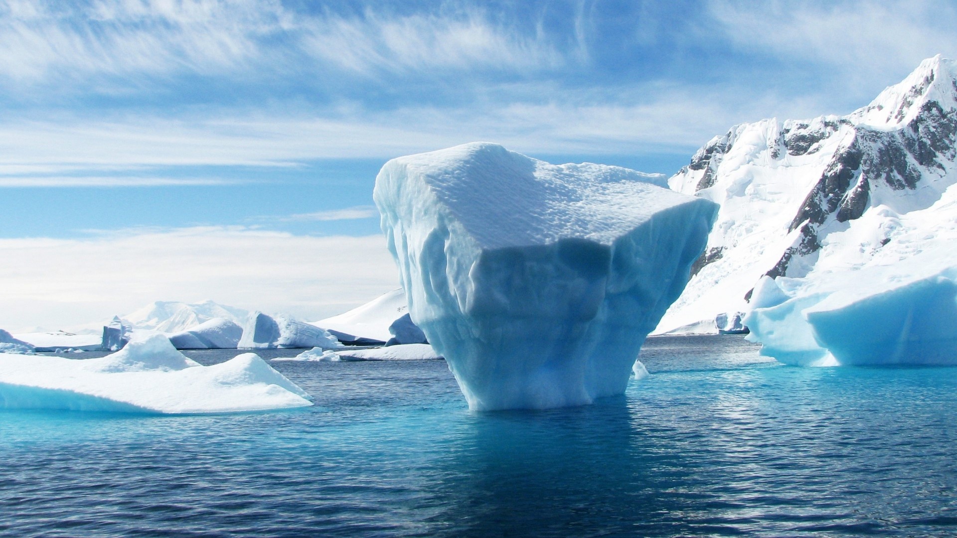 Icebergs floating in the ocean with snowy mountains HD Wallpaper