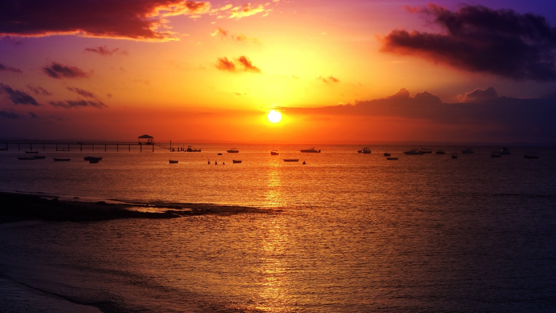 Sunset over the ocean with boats and pier HD Wallpaper