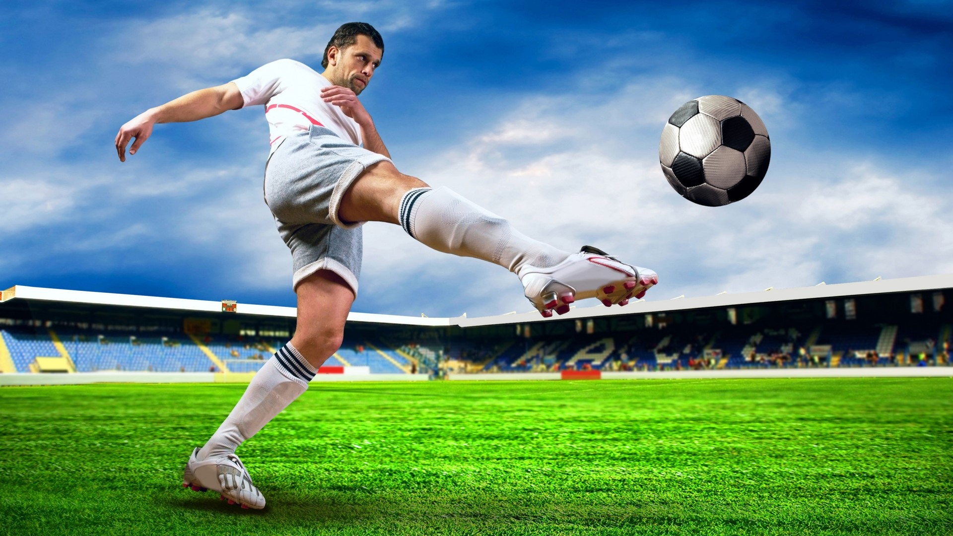 Soccer player kicking a ball on a stadium field HD Wallpaper
