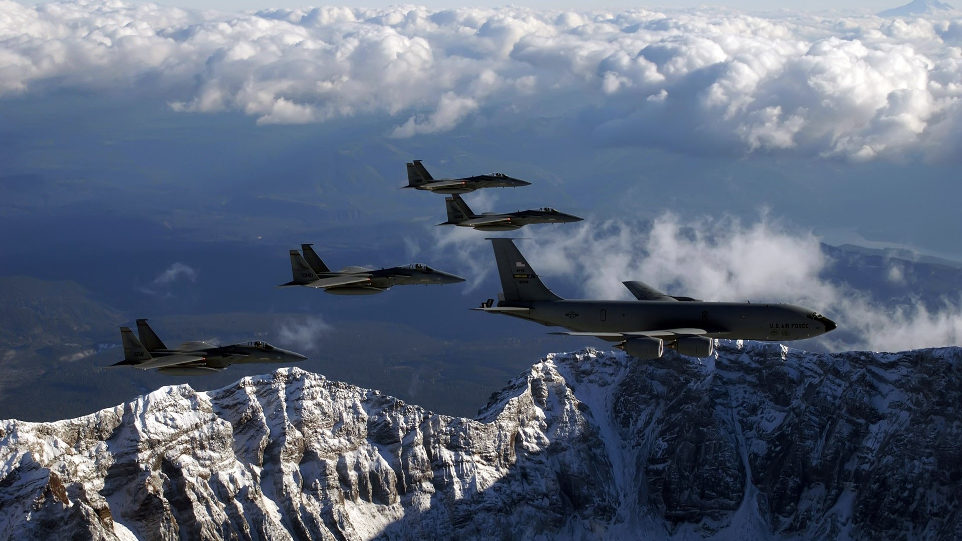 KC-135 Stratotanker and F-15 Eagles flying over mountains HD Wallpaper