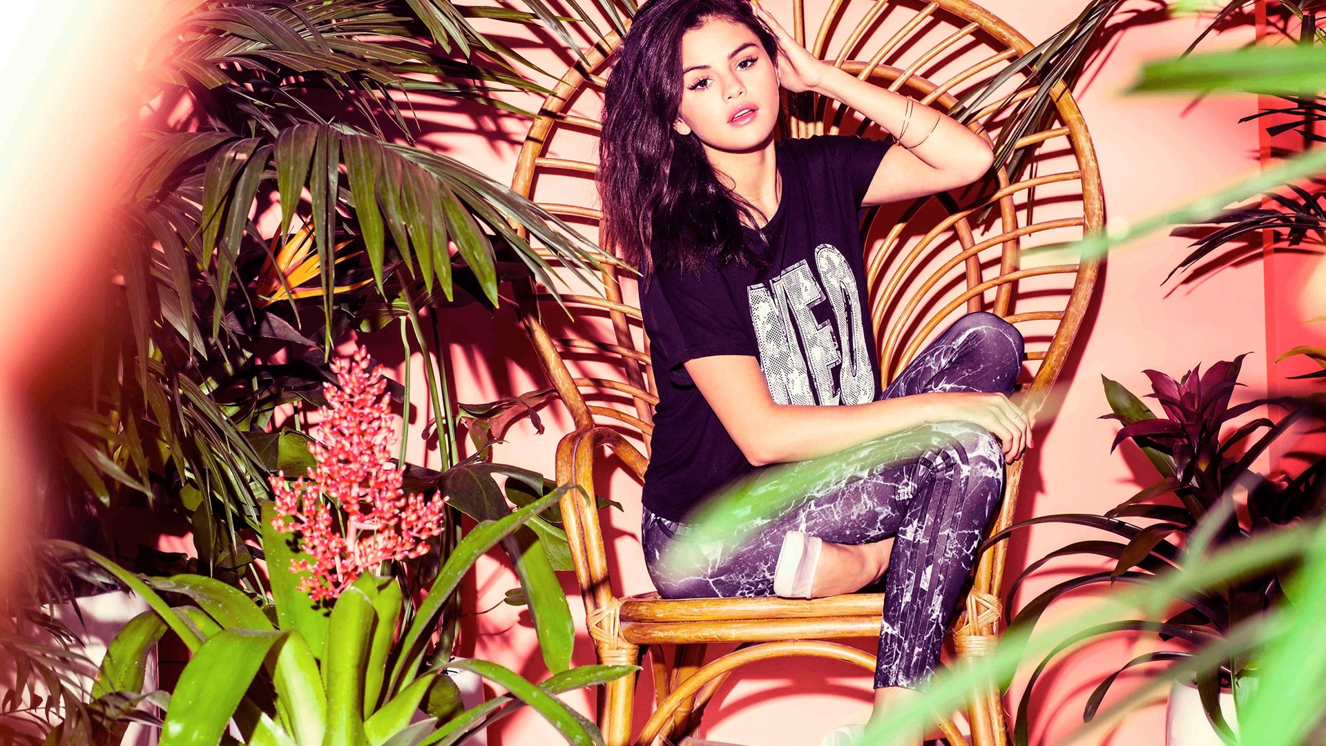 Selena Gomez sitting in a wicker chair HD Wallpaper