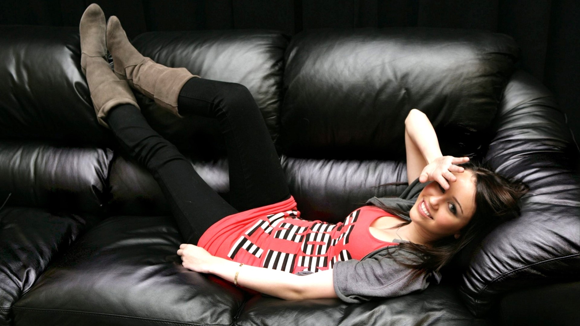 Miley Cyrus on a black leather couch HD Wallpaper