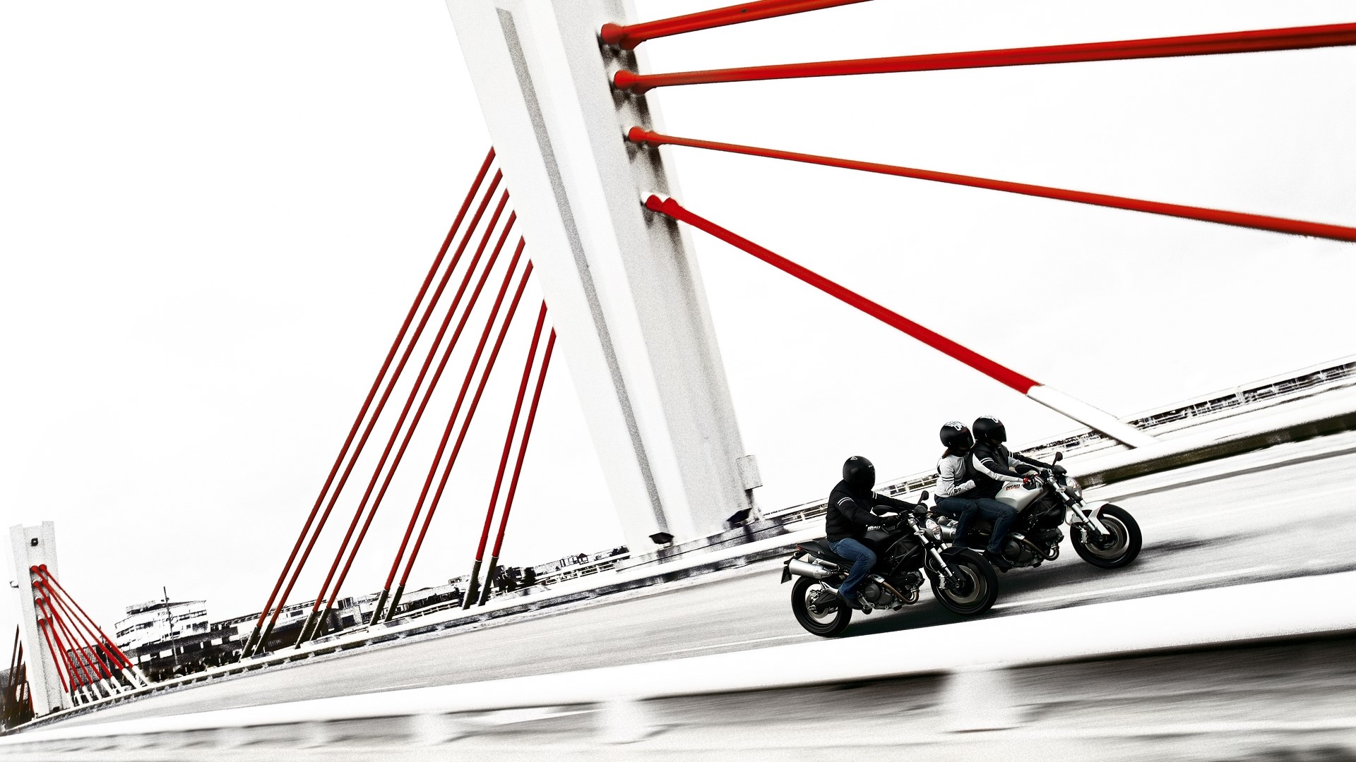 Motorcyclists on a bridge with red cables HD Wallpaper