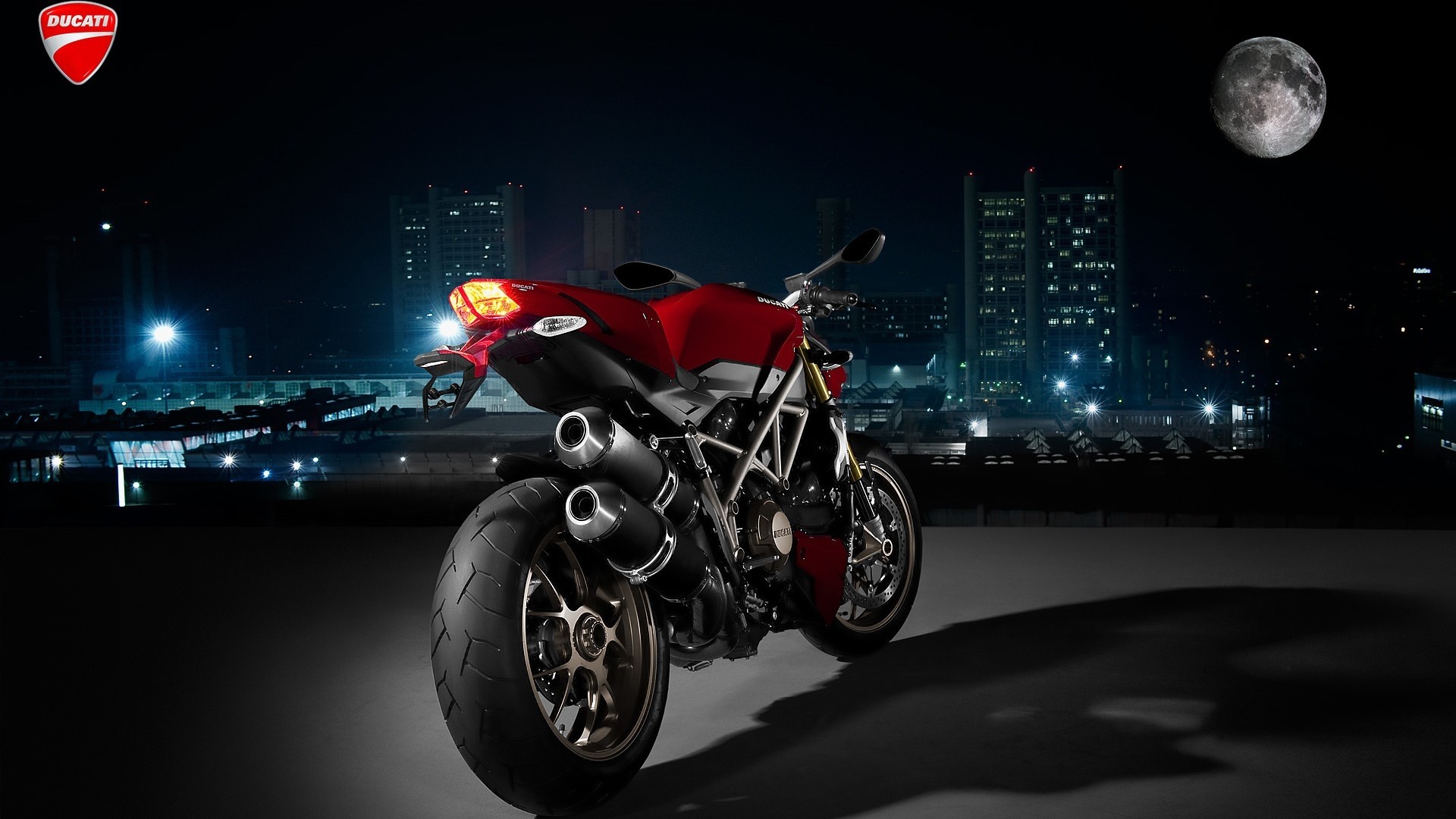 Ducati Motorcycle at Night with Cityscape and Moon HD Wallpaper