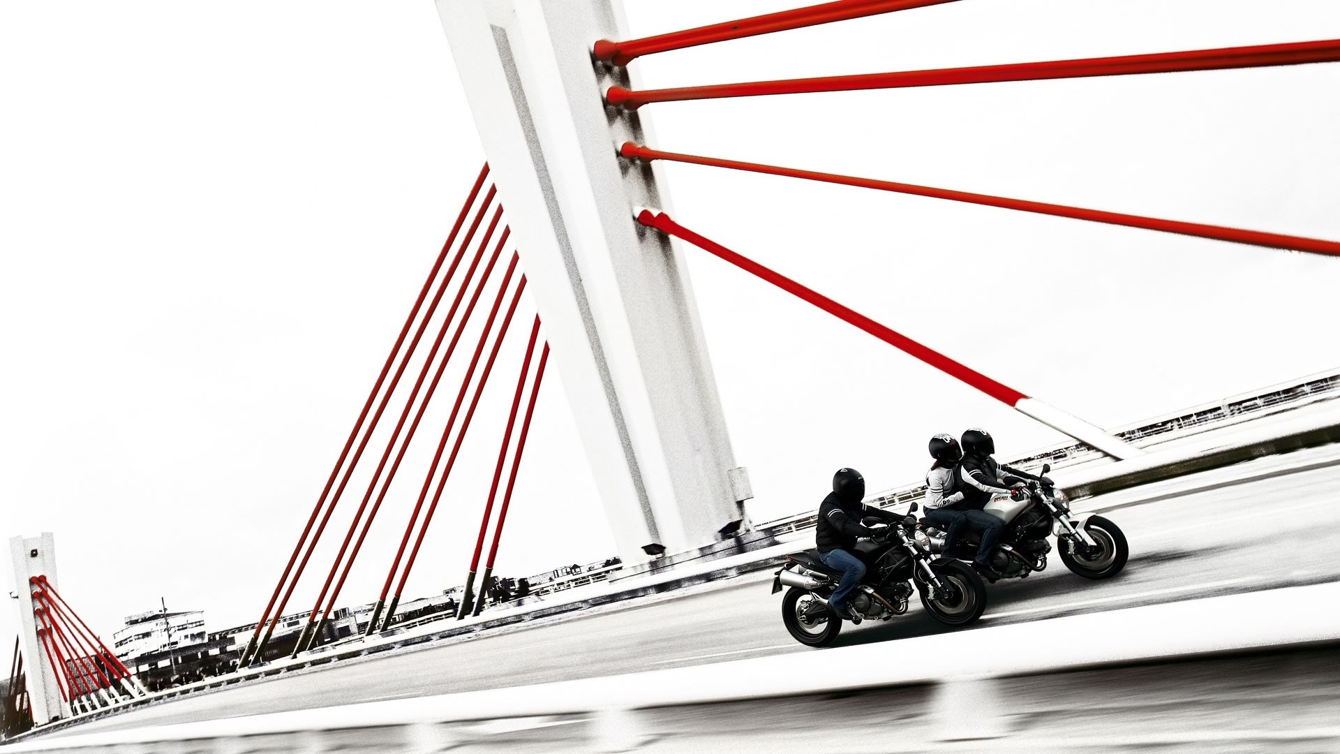 Motorcyclists on a bridge with red cables HD Wallpaper