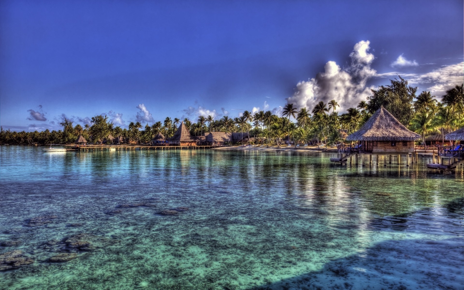 Overwater bungalows on a tropical island with clear turquoise water HD Wallpaper