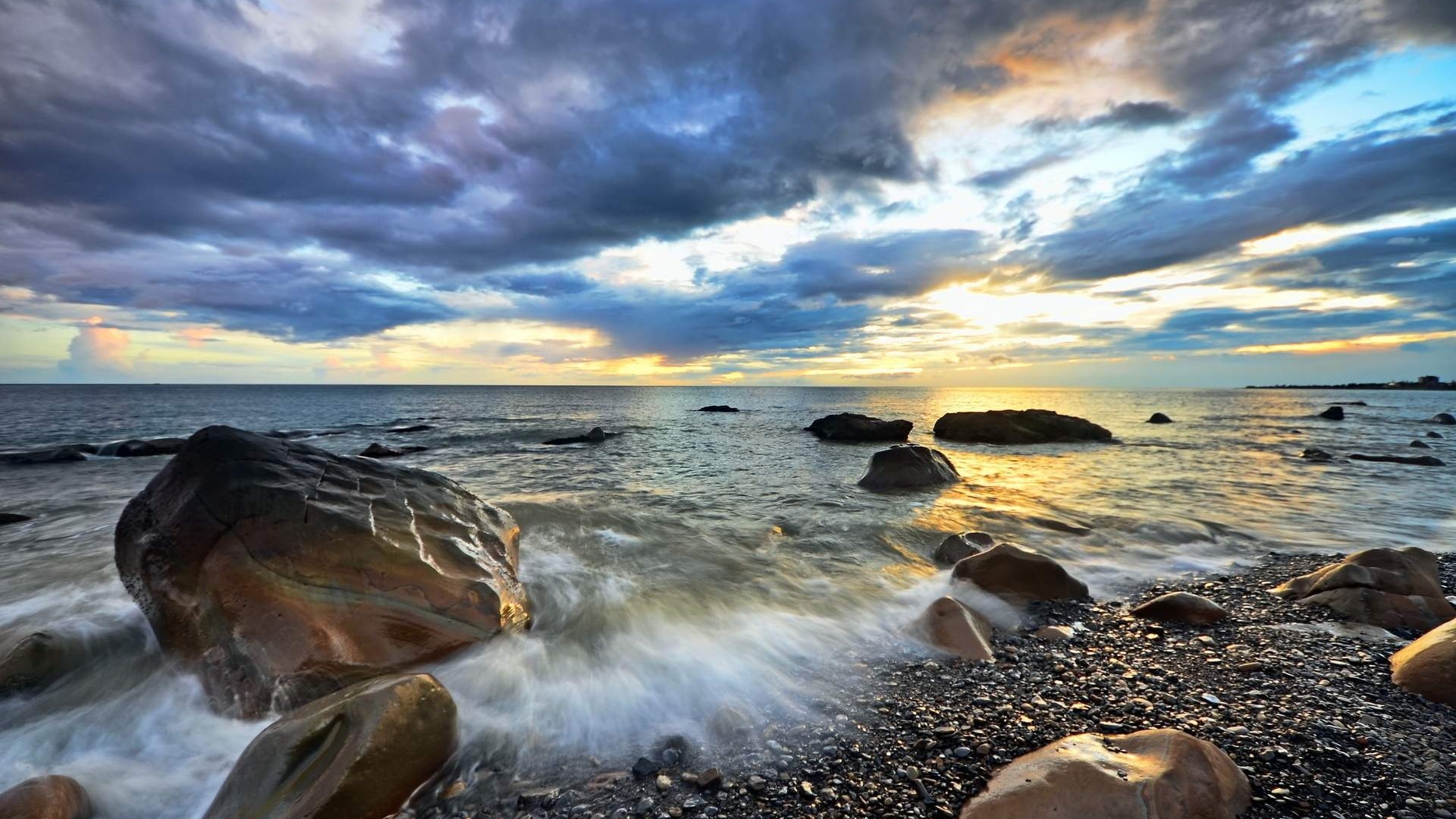 Rocky beach at sunrise with dramatic clouds HD Wallpaper