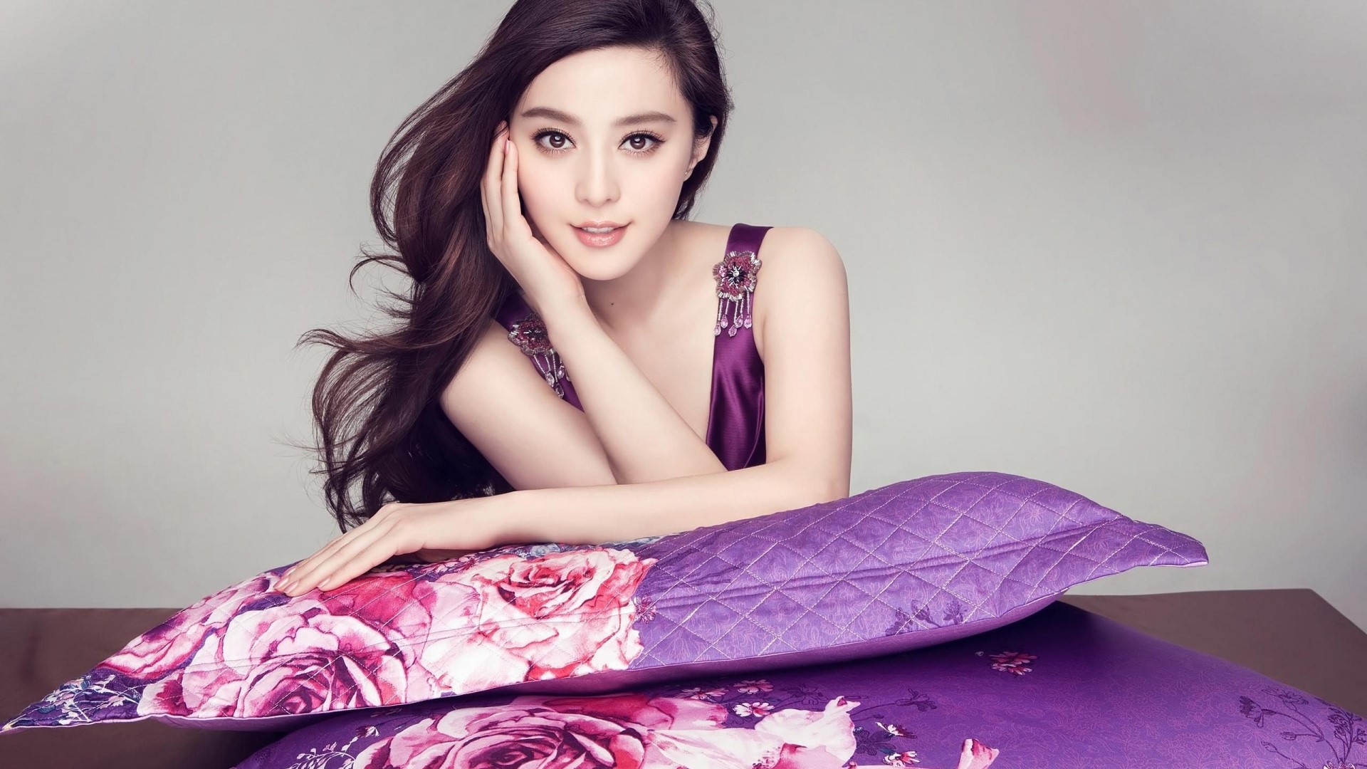 Fan Bingbing in purple dress with floral pillows HD Wallpaper