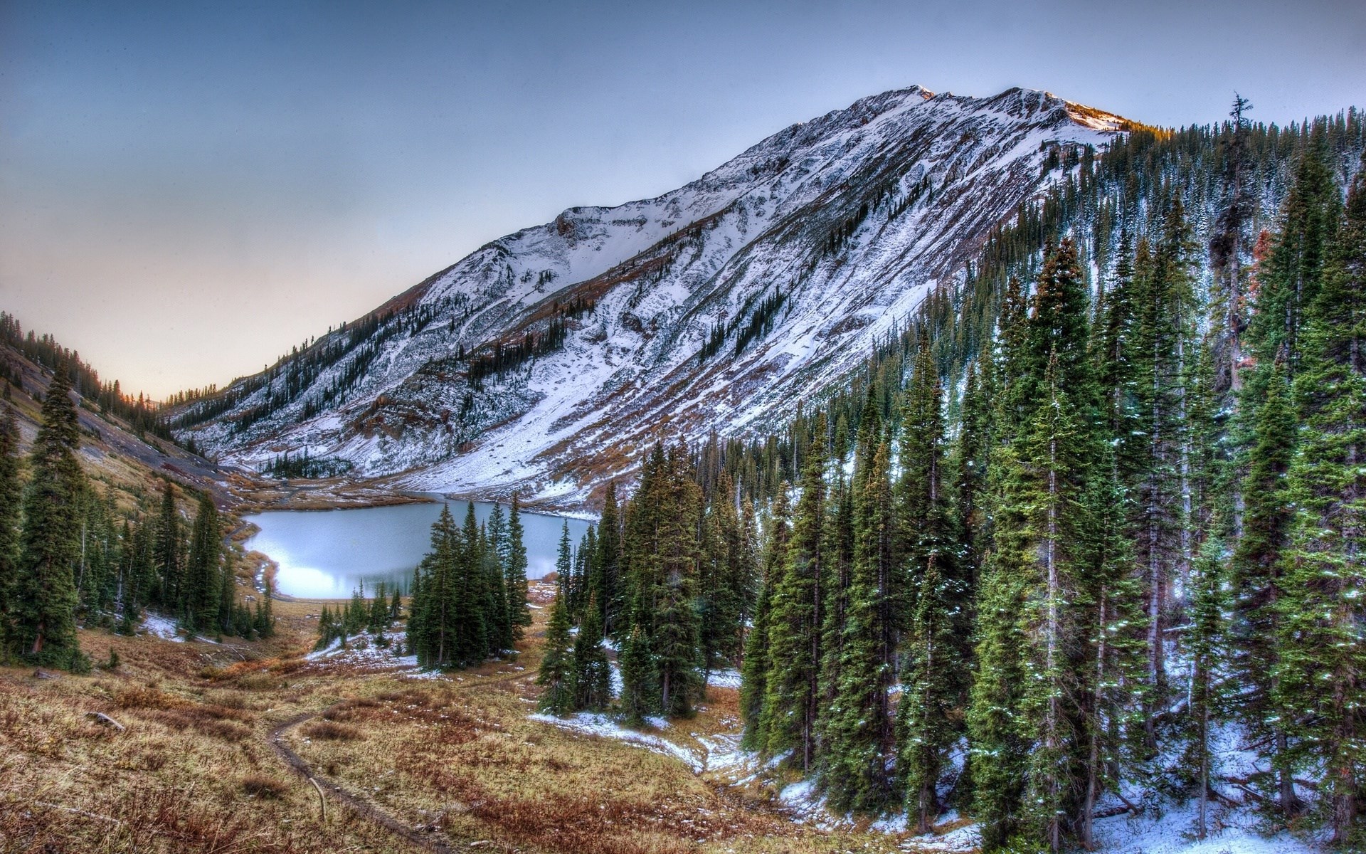 Snow-dusted mountain lake with pine forest HD Wallpaper
