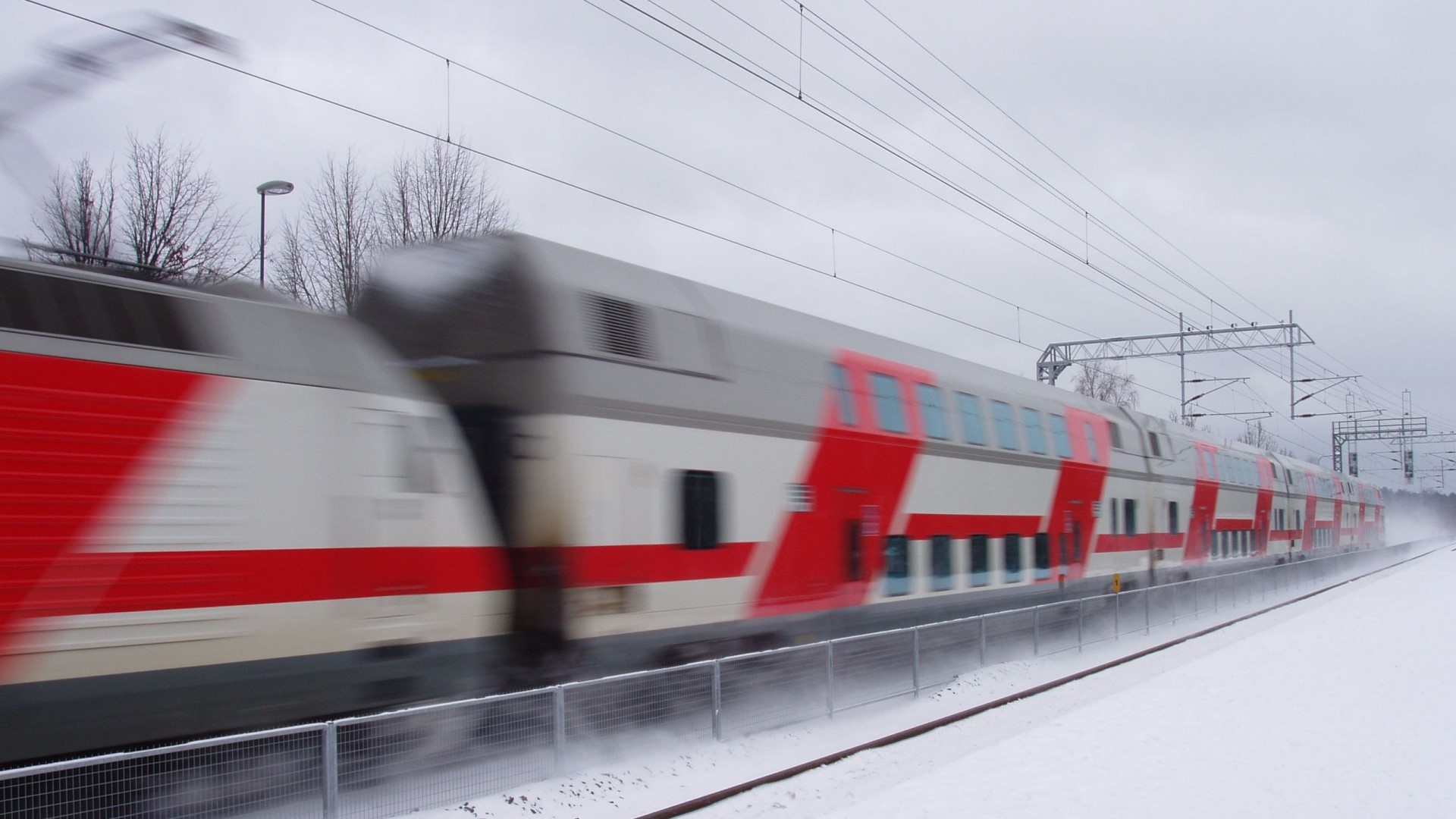 Train moving through a snowy landscape HD Wallpaper