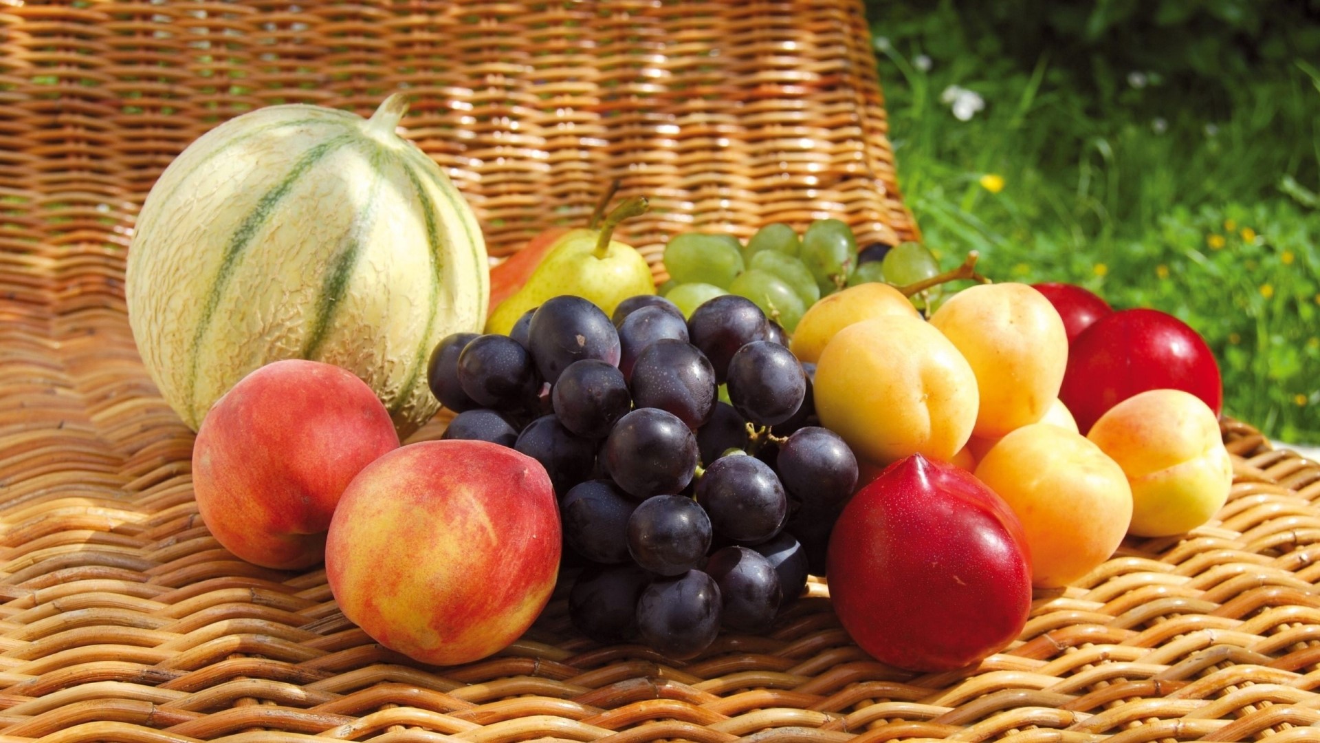 Assortment of fresh fruits on a woven surface HD Wallpaper
