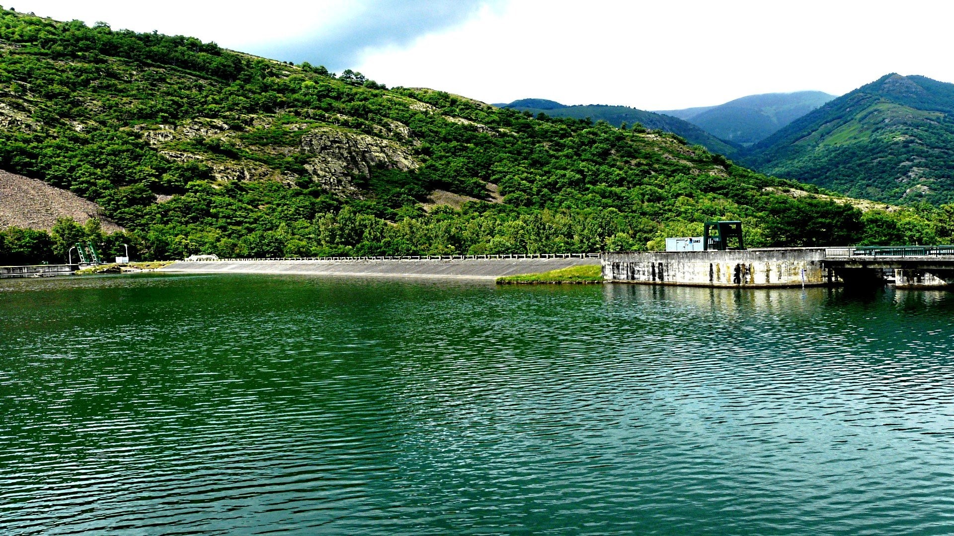 Dam and reservoir surrounded by green mountains HD Wallpaper