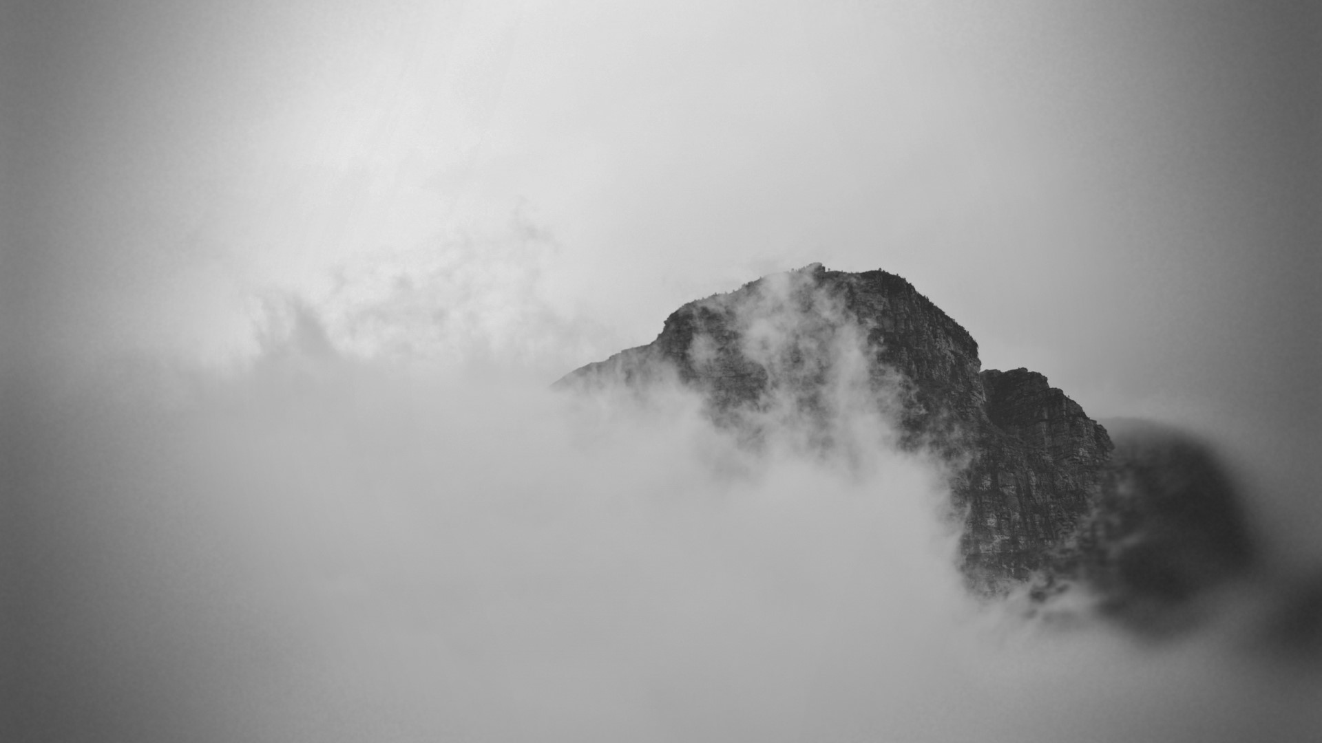 Mountain peak emerging from clouds HD Wallpaper