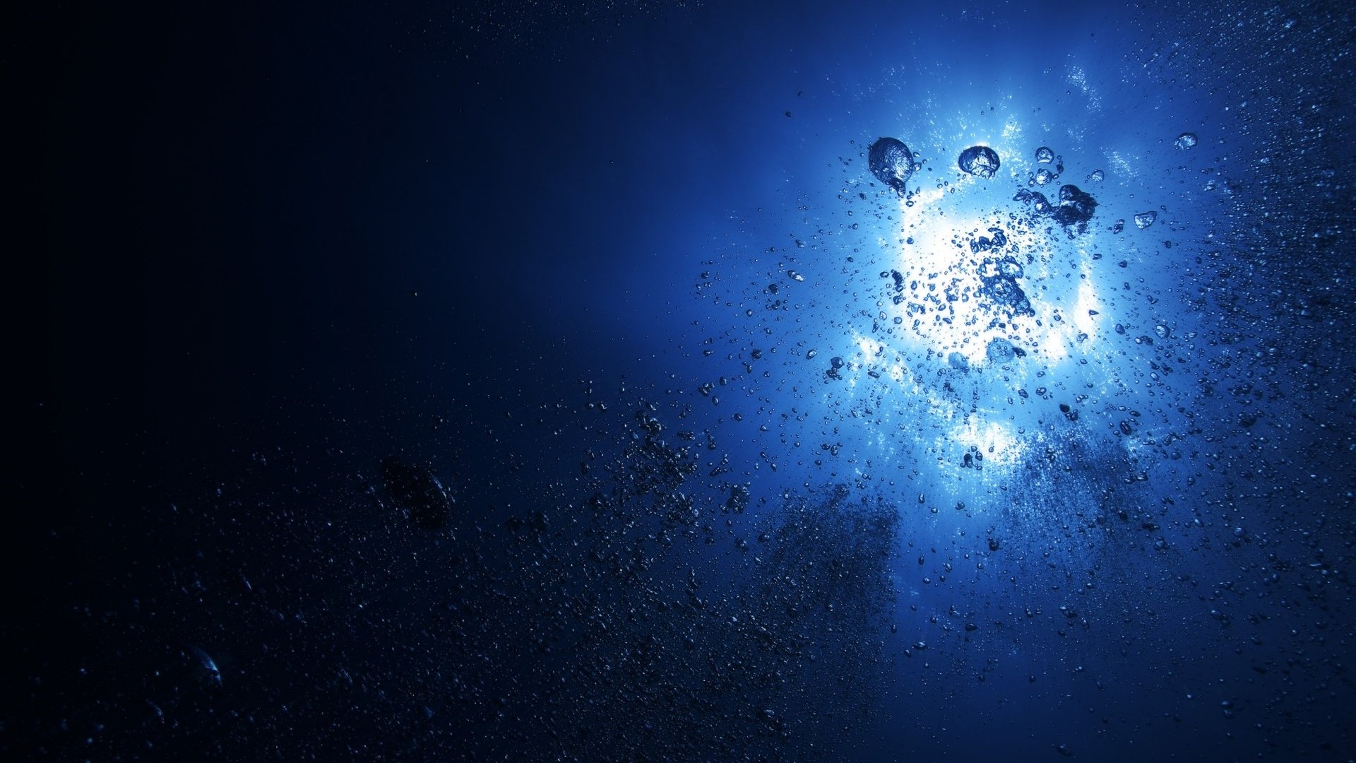 Bubbles rising towards sunlight underwater HD Wallpaper