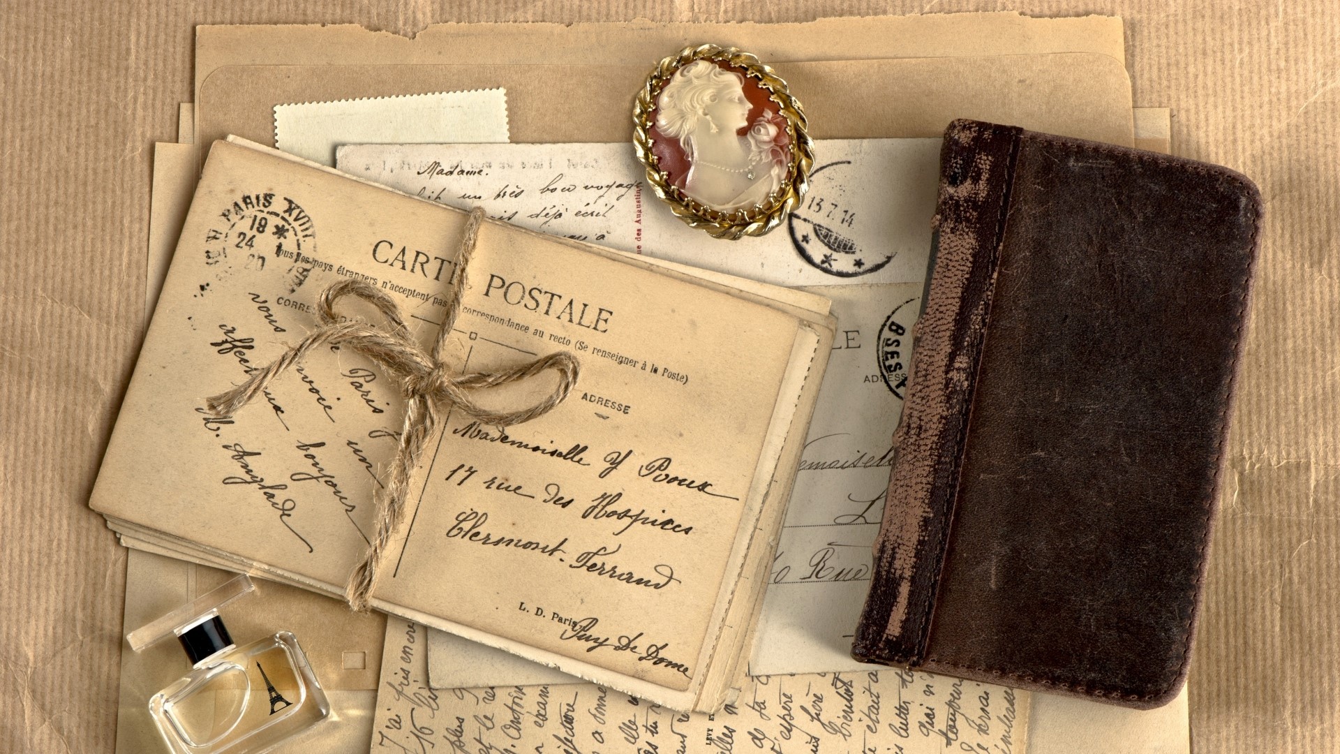 Vintage postcards, cameo brooch, and leather-bound book HD Wallpaper