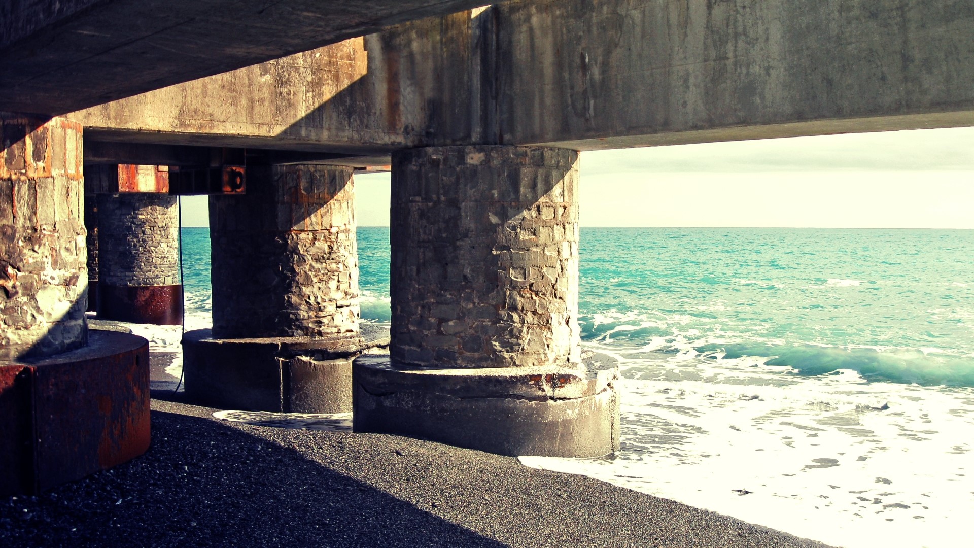 Under a concrete pier by the sea HD Wallpaper