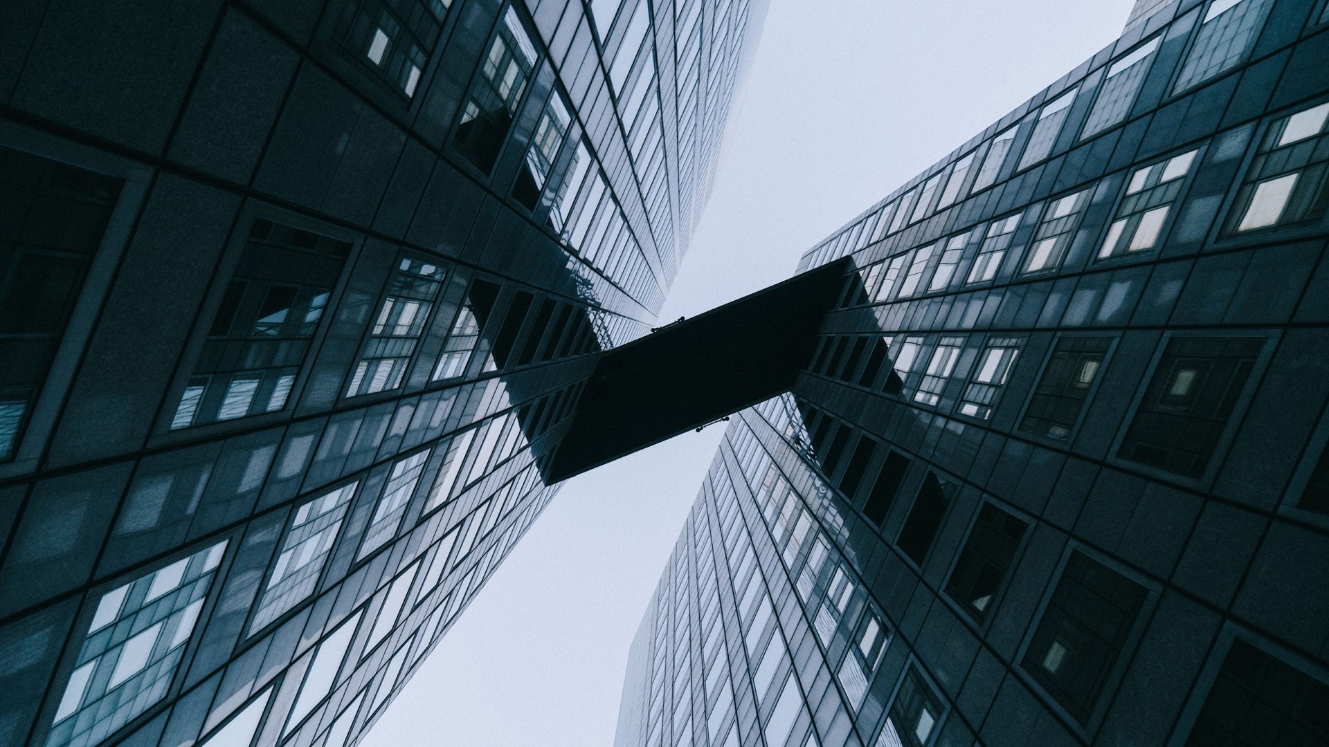 Two modern skyscrapers connected by a skybridge HD Wallpaper