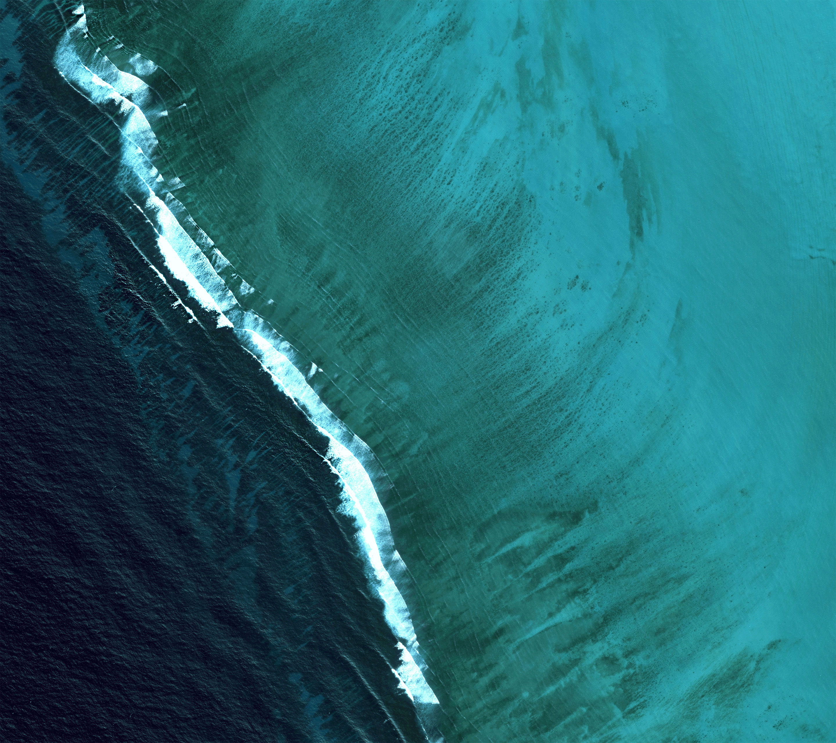 Aerial view of ocean waves crashing on a reef HD Wallpaper