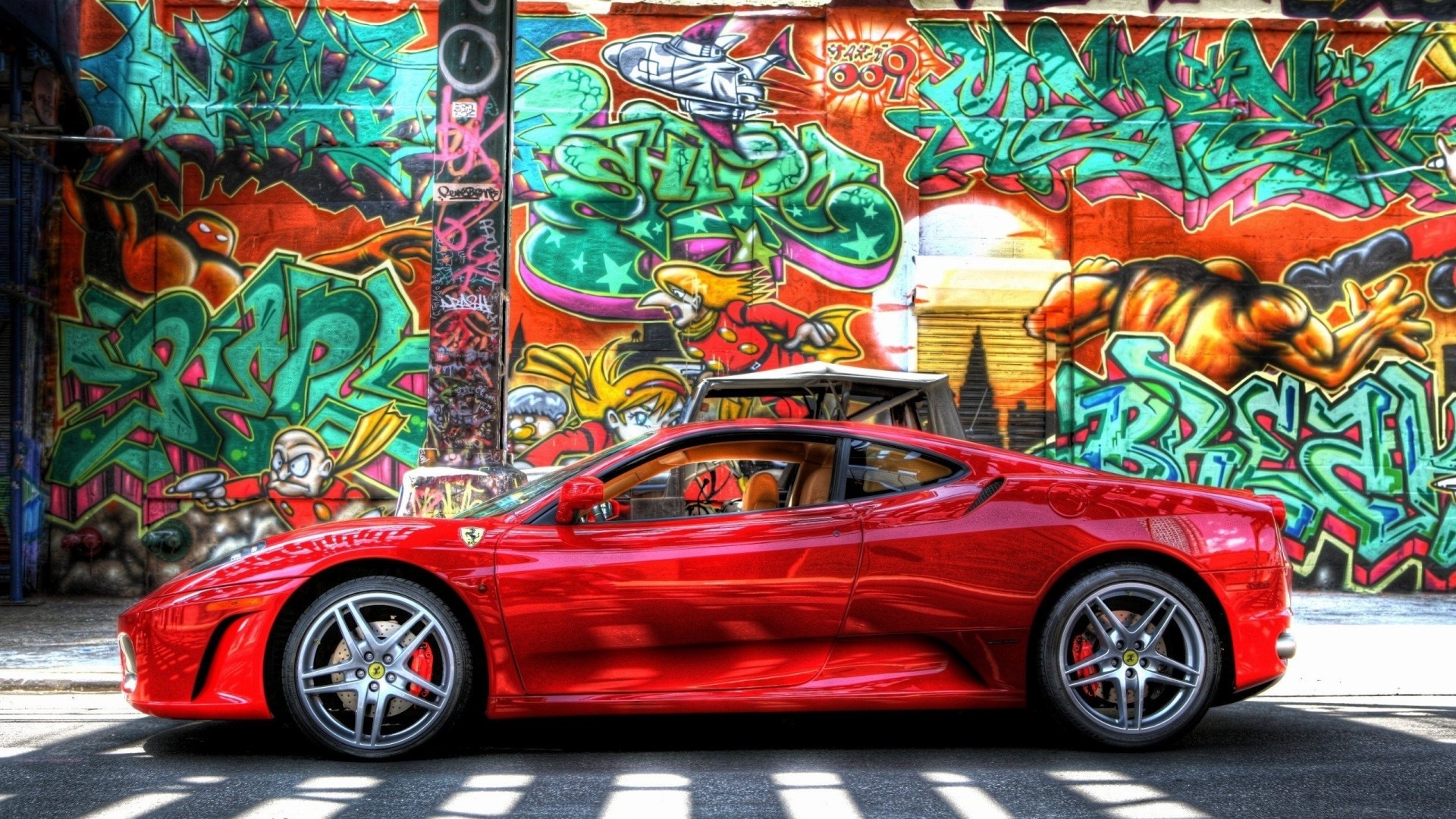 Red Ferrari parked in front of graffiti art HD Wallpaper