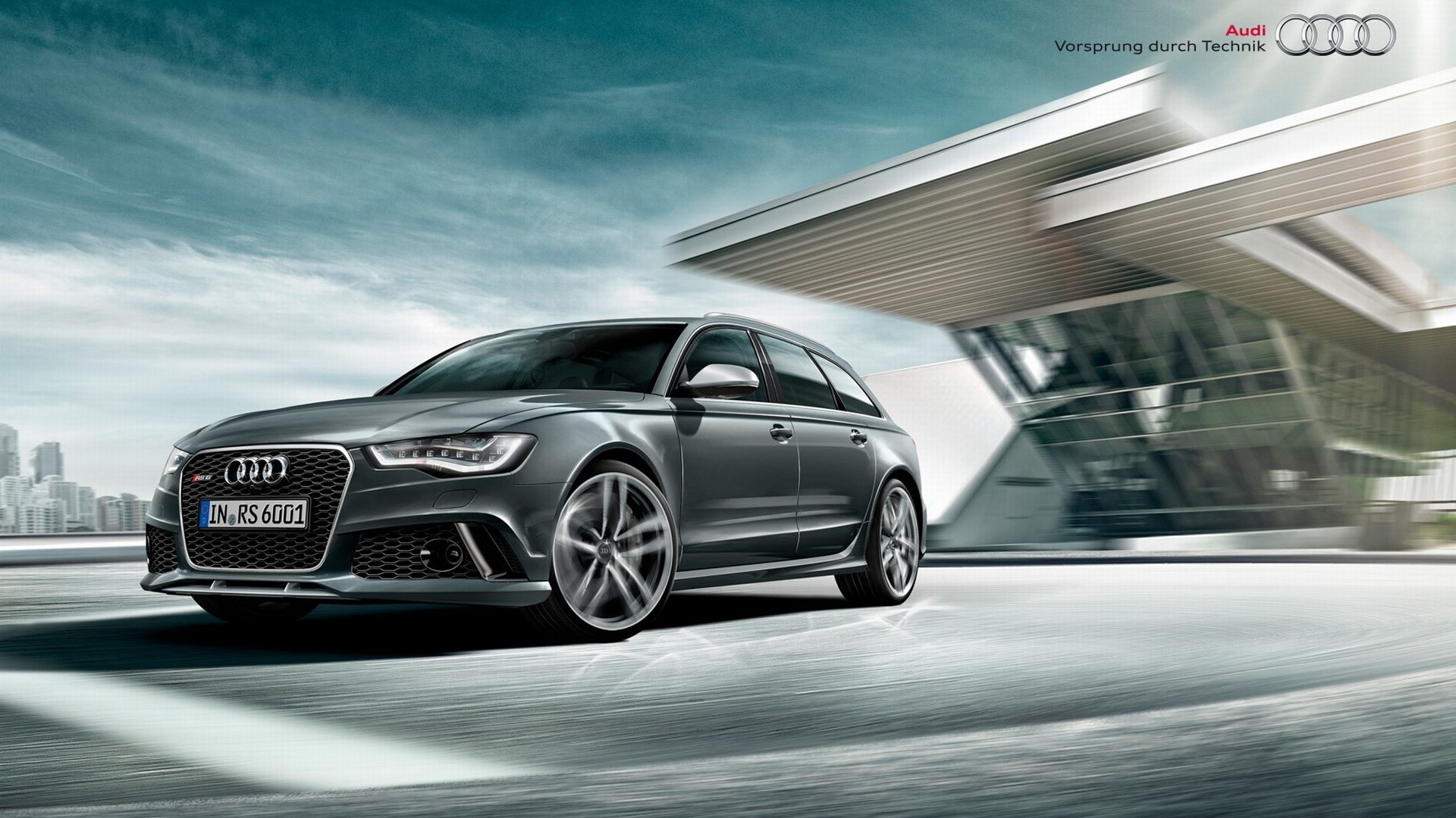 Audi RS6 Avant driving past modern architecture HD Wallpaper