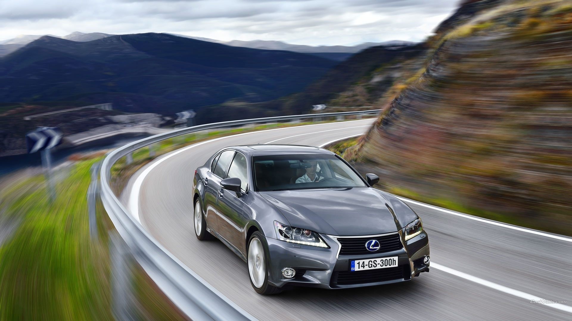Lexus GS F driving on a winding mountain road HD Wallpaper