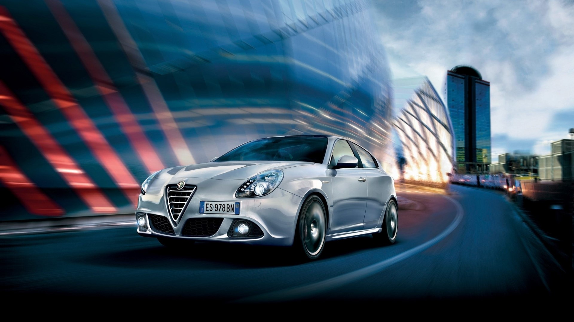 Alfa Romeo Giulietta driving on a city street HD Wallpaper
