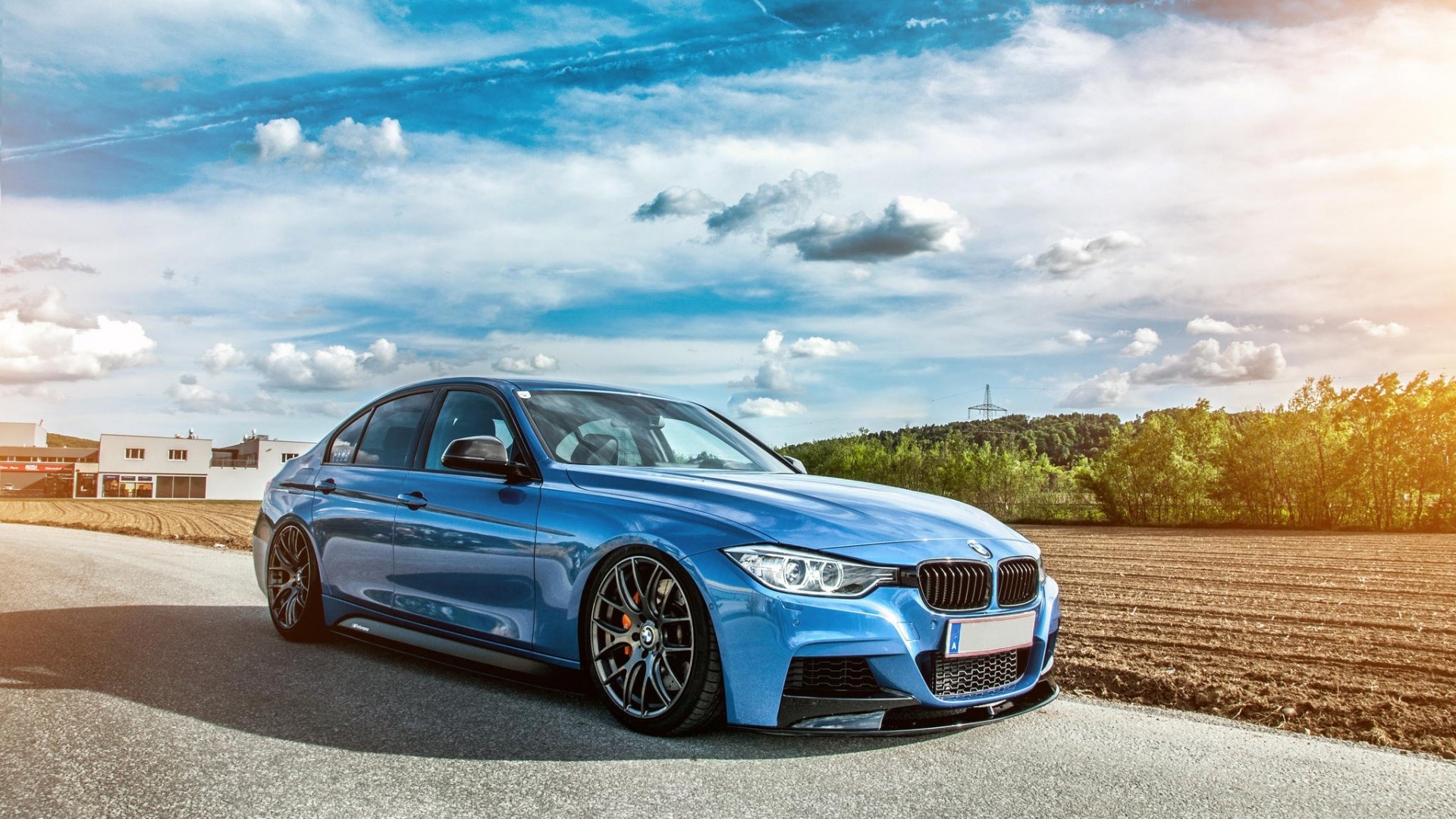 Blue BMW sedan parked on a road HD Wallpaper