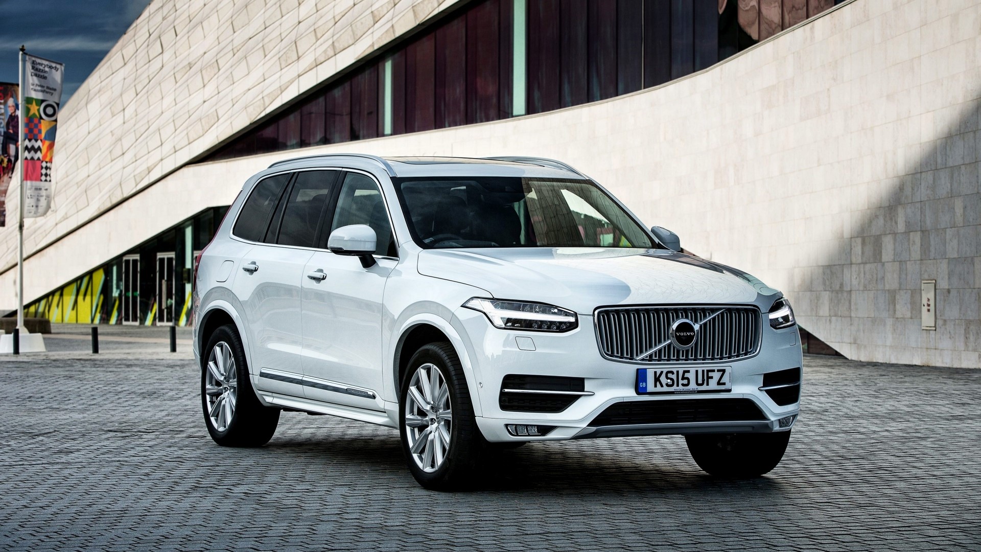 White Volvo XC90 parked in front of a modern building HD Wallpaper