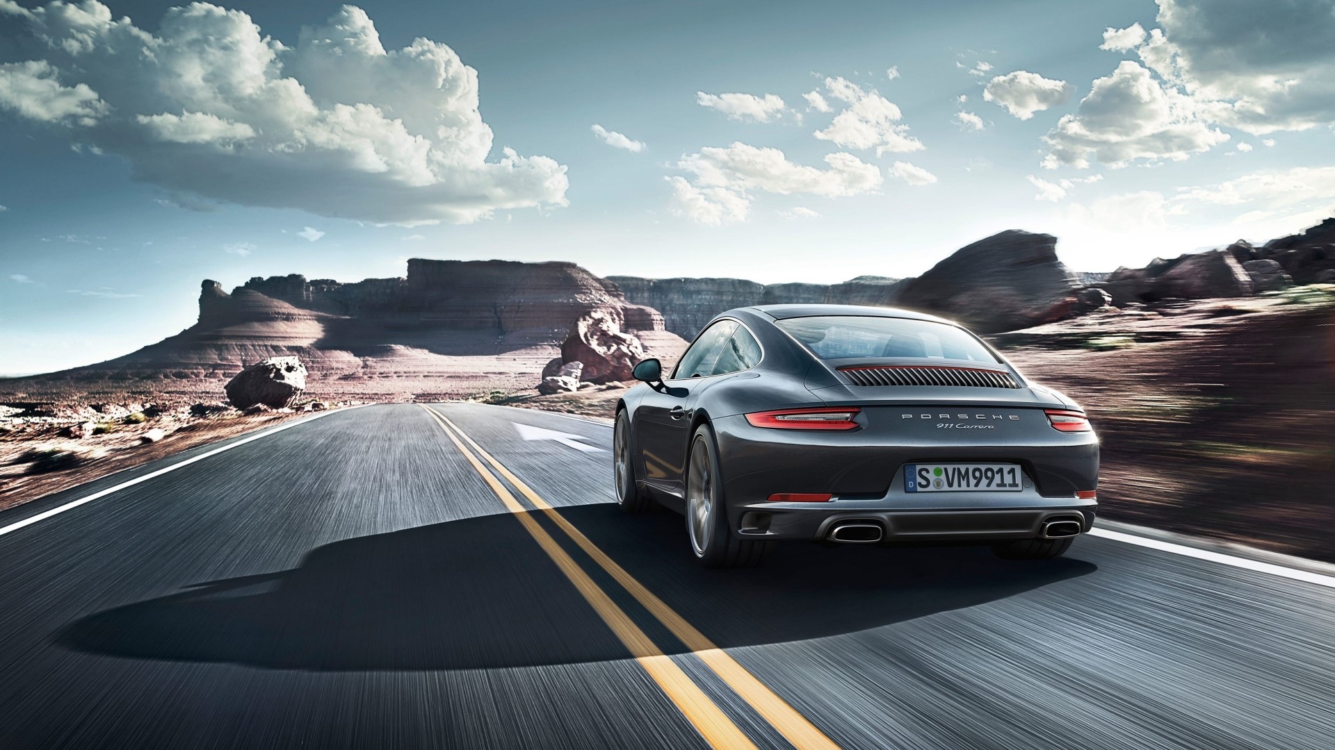 Porsche 911 Carrera driving on a desert road HD Wallpaper