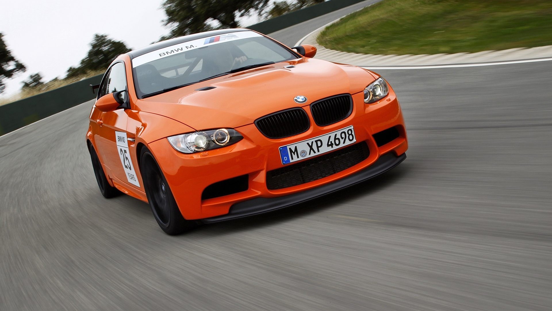 Orange BMW M3 GTS on a race track HD Wallpaper