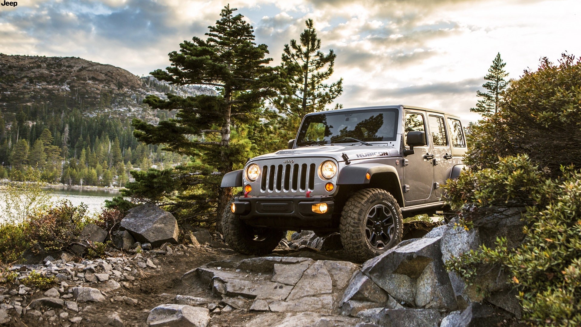 Silver Jeep Rubicon on rocky terrain HD Wallpaper