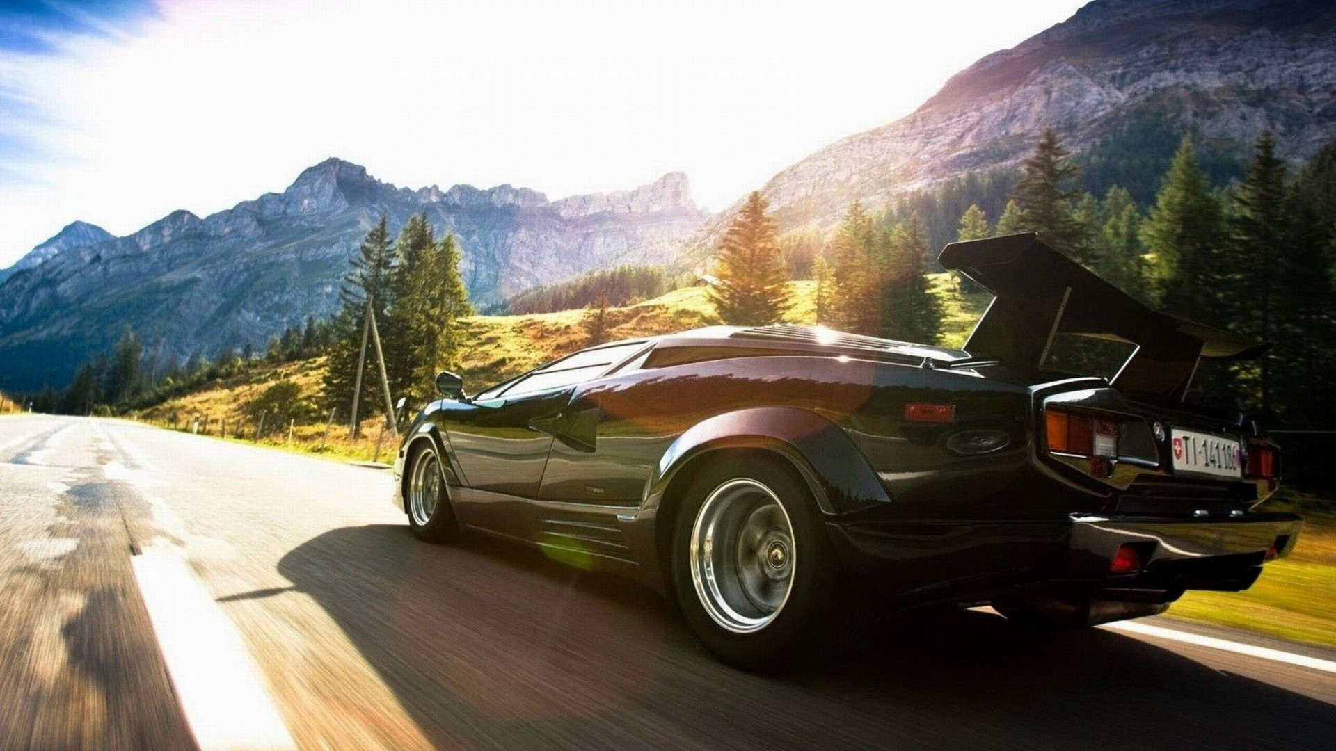 Black Lamborghini Countach driving on a mountain road HD Wallpaper